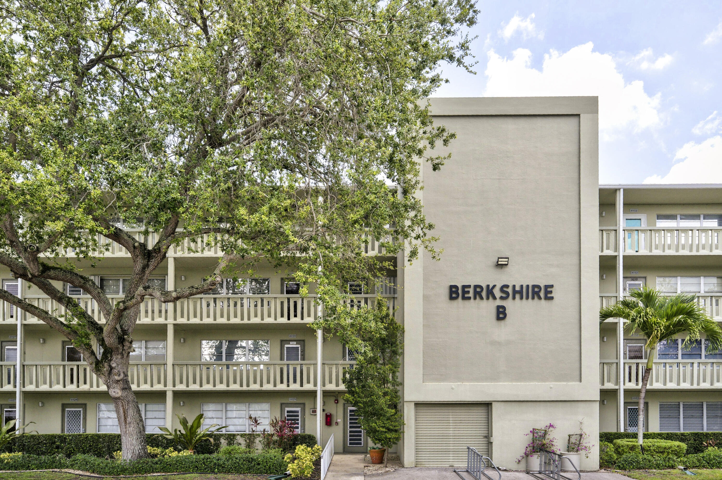 Prepare to be impressed by this meticulously updated, move-in-ready residence in the highly desirable Berkshire section of Century Village, Deerfield Beach! Nestled in a beautifully manicured building, this unit offers a bright, open floor plan styled with gorgeous wood-look flooring, sophisticated crown molding, and a soothing neutral palette.  The expansive living area flows seamlessly into a chef's dream kitchen, completely modernized with upscale white shaker cabinets extending to the ceiling, custom glass-front display cabinetry, rich dark countertops, a convenient breakfast bar, and stainless steel appliances.  Stunning Master Suite & Bath: The spacious primary bedroom features warm wood flooring and leads into a fully renovated master bathroom. This spa-like space boasts floor-to-ceiling porcelain tile, a sleek glass shower enclosure, a designer vanity with a rich granite countertop, and premium modern lighting.  Custom Walk-In Closet: Storage is a breeze with a magnificent, professionally designed walk-in closet packed with custom built-in dressers, adjustable shelving, and multi-level hanging racks.  Flexible Guest Spaces: The generous second bedroom features matching wood flooring and sleek built-in storage units, located right next to a clean, bright second full bathroom.  Massive Enclosed Florida Room: Step through sliding glass doors into an expansive, tiled patio. Flooded with natural light and overlooking a peaceful green courtyard, this space includes a ceiling fan, wall AC, and a massive bank of built-in storage cabinets—perfect for a den, sunroom, or private home office.  Located in a premier 55+ gated resort community, you are steps from the Berkshire satellite pool and a short walk to the main clubhouse, indoor/outdoor pools, fitness center, and free community shuttle. This turnkey gem offers South Florida condo living at its absolute finest!