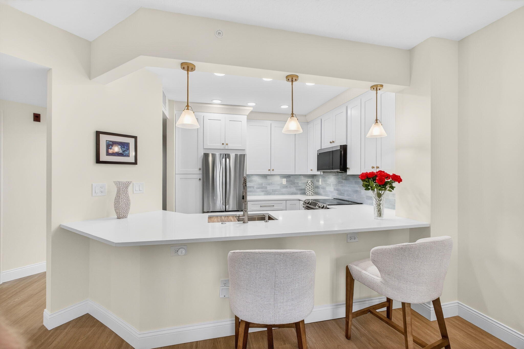 Move-in ready and beautifully updated, this stylish condo is located in a gated community offering resort-style amenities including two pools, jacuzzi tubs, fitness center, and BBQ area--just minutes from beaches, boating, golf, fine dining, shopping, and restaurants. Interior highlights include premium Ceramin Icon waterproof composite mineral core flooring throughout , fresh interior paint, custom plantation shutters, and updated baseboards, trim, electrical outlets, and door hardware. The renovated kitchen features Highland lacquer wood cabinetry with soft-close drawers, quartz countertops, ceramic tile backsplash, recessed lighting, and stainless appliances including a new Samsung microwave, LG refrigerator, Samsung range. The updated bathroom offers custom cabinetry, quartz countertops, Kohler sinks, Grohe faucets, and modern backlit mirrors. Additional highlights include a custom walk-in closet, built-in storage with floor-to-ceiling patio closet shelving, LG washer/dryer, screened patio with new screens and hardware. Detailed list of upgrades available!