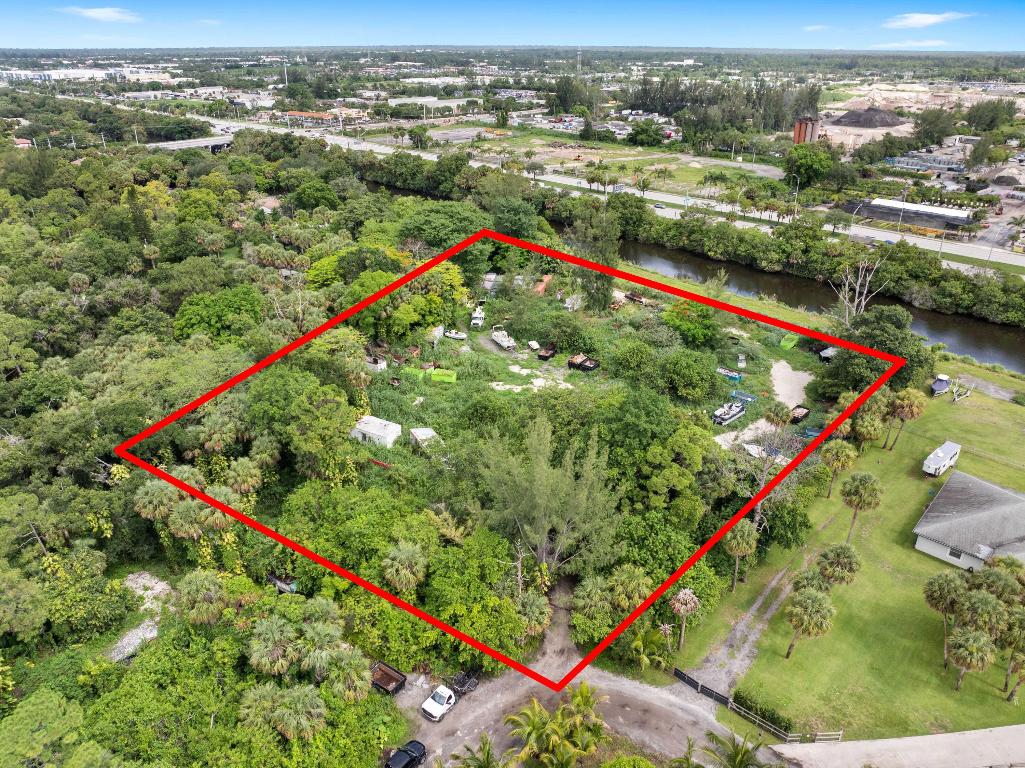 Vacant land. Incredible 5.04-acre waterfront property featuring approx. 3.04 acres of upland and a 2.00-acre private road easement. Fully fenced and gated, with 600 feet of water frontage on the C-51 Canal, a navigable waterway maintained by the U.S. Army Corps of Engineers. Riparian rights included, allowing the opportunity to build a private dock and keep your boat in your backyard. The deeded 60-ft private road offers rare privacy and control. Ideal for adding a gated entrance. No HOA. Located near Southern Blvd and the Turnpike, just 15 mins to PBI Airport. Sail to Lake Osborne. A truly one-of-a-kind, build-ready site in a rapidly developing area. Survey can be found under ''documents''.