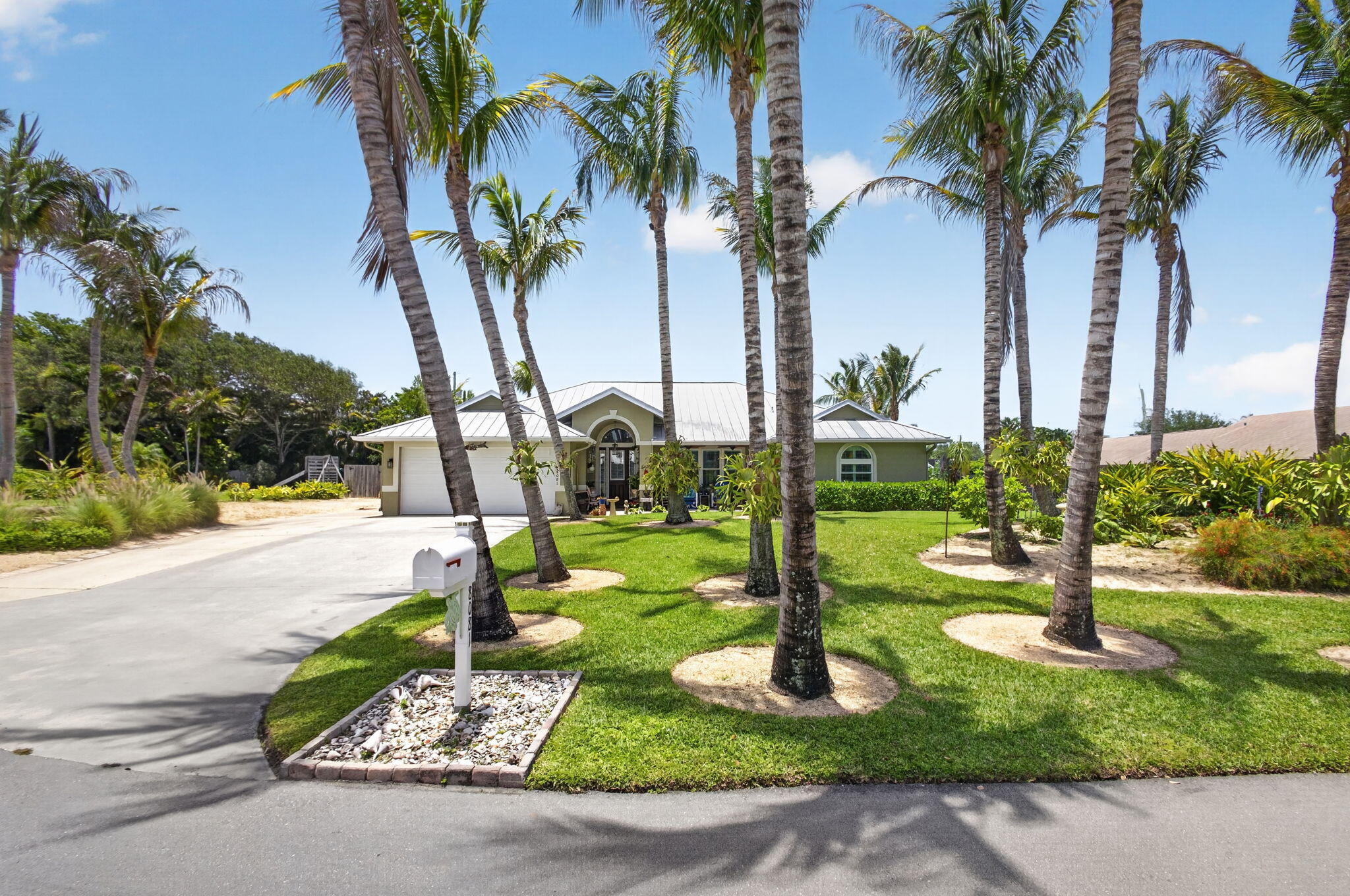 Perfectly positioned in the highly desirable Heritage Plantation community off Gomez Avenue in the heart of Hobe Sound, this exceptional residence showcases an impressive collection of premium upgrades that seamlessly blend timeless design, modern efficiency, and refined coastal living. Thoughtfully reimagined with an open-concept floor plan, the home features rich acacia hardwood flooring, custom wood plantation shutters throughout, and a whole-home integrated sound system extending to the front porch, rear lanai, and hot tub area. Built for lasting peace of mind, it offers impact windows, spray foam attic insulation, a standing-seam metal roof, and a solar energy system, delivering an av FPL bill of approximately $45 per month. The beautifully appointed kitchen is designed for  everyday living and effortless entertaining, featuring a gas range, premium appliances, a drawer microwave, and a wine cooler. The washer, dryer, garage refrigerator, and upright freezer are all included. Outdoors, elegant paver brick accents enhance the front porch and pool deck, complemented by a 12' x 10' storage shed for added convenience. Even the guest bath has been thoughtfully designed and is already plumbed for a future double vanity. Every enhancement reflects exceptional craftsmanship and meticulous attention to detail, creating a residence that is as luxurious as it is effortlessly livable.Beyond the home, Heritage Plantation offers a rare combination of privacy and community with mature tree-lined streets, generous homesites, and a welcoming neighborhood atmosphere. Ideally located just minutes from Hobe Sound's pristine beaches, boating, and a public boat ramp located within approximately one mile of the residence, this exceptional location also provides easy access to championship golf courses, waterfront dining, nature preserves, and the charming downtown district. With convenient access to Jupiter, Stuart, and Palm Beach, you'll enjoy the perfect balance of peaceful coastal living and everyday convenience.