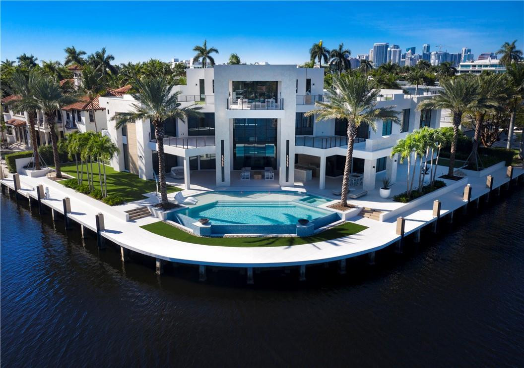 Stunning Coastal Modern point residence offers incredible views & 258 ft excellent protected deep water dockage for large/ multiple yachts (136 ft on Rio Barcelona & 121 on side canal). Custom quality construction poured on site concrete, 150+ pilings, latest home technology. Imaginative & highly flexible floorplan.3 levels of luxurious accommodations! Outstanding Chef's kitchen, family room & amazing entertaining areas,1st level VIP suite, additional bedroom plus office/gym.2nd level: open club room, extraordinary Master retreat, large separate custom closets & spa style bath access huge private covered balcony. 3 additional bedroom suites & Captain's/Mother In Law Suite with private staircase access. 3rd level - ultimate Club room with covered lounge area, outdoor shower & open roof deck