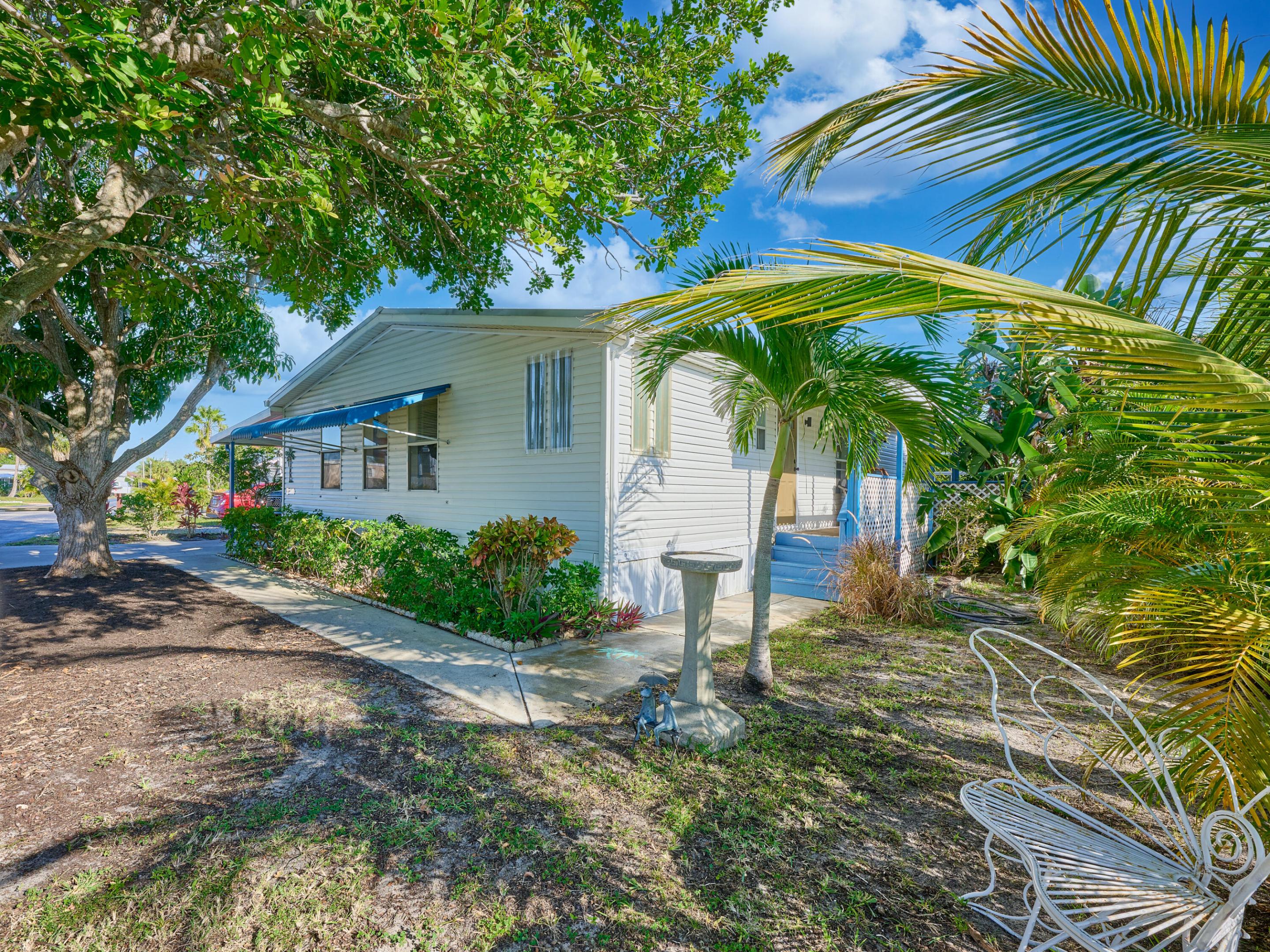 1.5 MILES TO HOBE SOUND BEACH. BOAT/RV STORAGE AVAILABLE.  2 BEDRM/2 BATH SPACIOUS 1998 MANF HOME. WIDE OPEN PLAN!! WOODBRIDGE 55+ COMM. WHICH DOES ALLOW 35 Y.O. IF LIVING W 55+ SHARE HOLDER. BEAUTIFUL KITCHEN W SOLID SURFACE COUNTERS, WHITE CABINETS & PANTRY W PULL OUT SHELVES. COVERED PORCH OVERLOOKING PRIVATE TROPICAL YARD - NO HOMES ON RT OR BEHIND HOME. LR W EXTRA STORAGE LEADS OUT TO 20X10 GLASSED IN & SCREENED FL RM - OFF THAT ANOTHER 10X10 SCREEN RM. HUGE MASTER W DOUBLE DOOR ENTRY & ENSUITE BATH w DUAL SINKS, SOAKING TUB & STEP IN SHOWER. GOOD SIZE 2ND BEDRM & 2ND FULL BATH. NEW A/C 2022, METAL ROOF JUST RE-SEALED! SOARING CEILINGS - WINDOWS GALORE! NEW EXTERIOR DOORS AND PAINT. ACTIVE CLUBHOUSE, HEATED POOL, SHUFFLEBOARD & ACTIVITIES. $250/MO FEE INCLUDES WATER/SEWER/CABLE