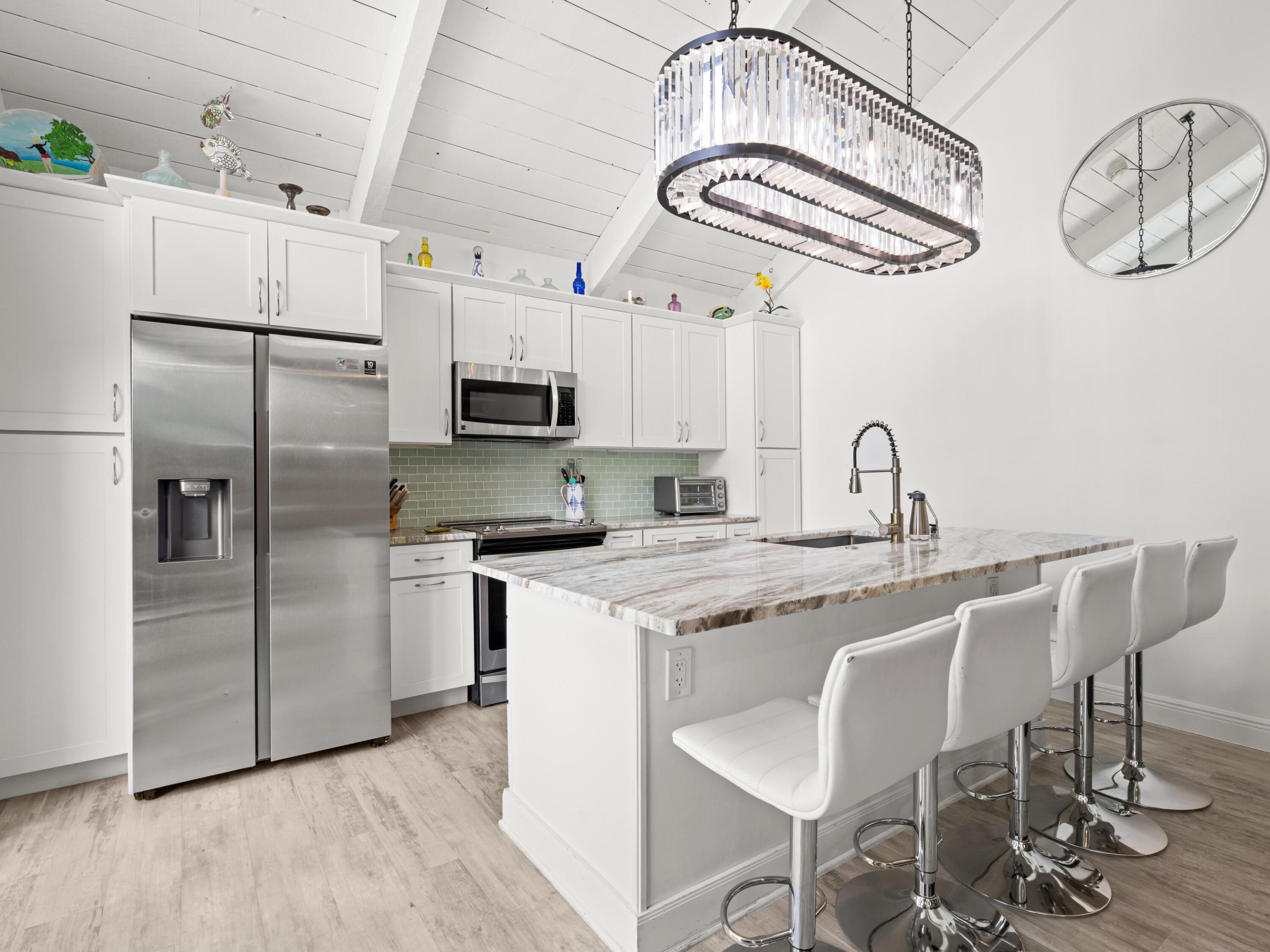Just a short distance from Jupiter Beach, this beautifully renovated 2-bed, 2-bath home offers the ultimate blend of coastal charm, modern updates, and investment potential. Located in an idyllic beachside community, the unit has been thoughtfully upgraded with marble countertops, stainless steel appliances, luxury vinyl flooring, impact windows and doors, and plenty of storage throughout. The private courtyard is ideal for entertaining, grilling, relaxing, or storing beach gear, and features a convenient outdoor shower for rinsing off after a day at the beach. A private upper deck provides an additional outdoor retreat. Take your tennis game to the next level with on-site pro-shop and courts. Whether a primary residence, 2nd home or rental property, this home checks all the boxes.