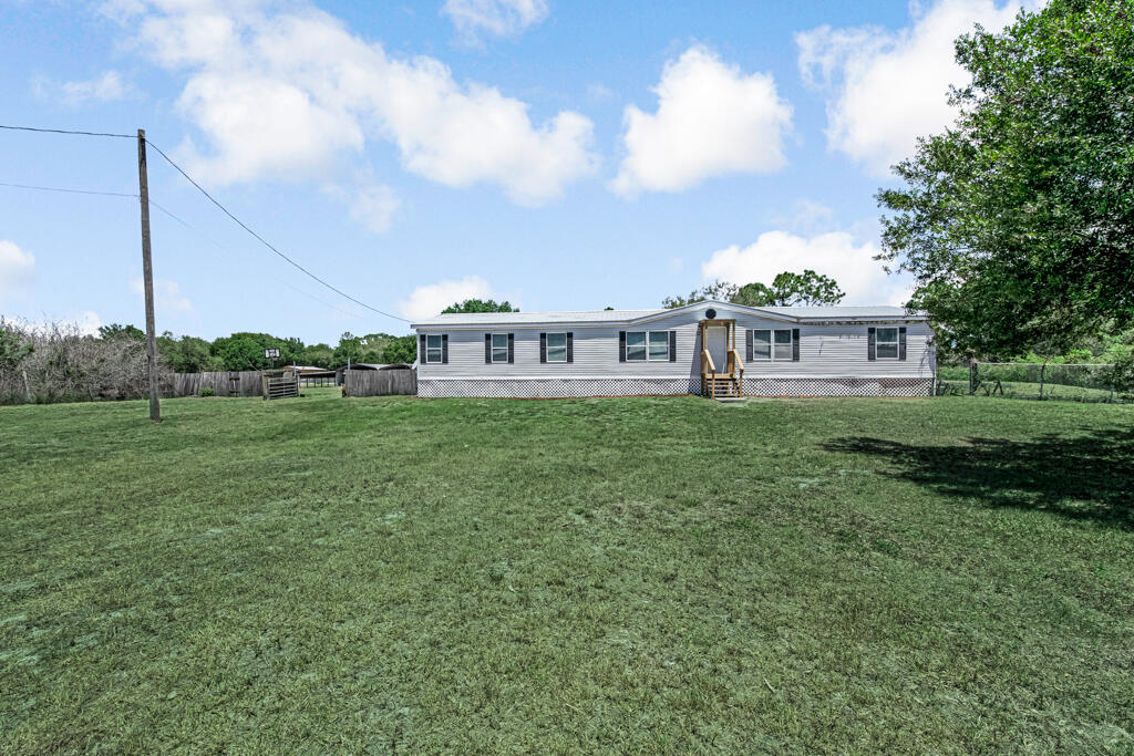 Located in one of the most desirable areas of Montura Ranch Estates, this beautifully maintained 4-bedroom, 2-bath double-wide home offers the perfect blend of privacy, space and convenience. Situated on a partially fenced and gated 2.5-acre corner lot with paved road access. This move-in-ready property is ideal for those seeking peaceful country living with modern comforts. The home features a durable metal roof for long-term peace of mind, along with an updated kitchen complete with modern appliances. Laminate flooring runs throughout and both bathrooms have been updated, including new showers by Bath Fitter.  Enjoy relaxing evenings on the screened-in back porch, perfect for taking in the serene surroundings.  The property also includes two oversized 40' x 18' sheds with electrical amps (50, 30 and 15) plus an additional storage building, providing ample space for equipment, hobbies or workspace. Additional highlights include an updated water filtration system, an added light pole for enhanced nighttime visibility. With no HOA restrictions and horses permitted, this property offers flexibility for a variety of uses. Ideal for entertaining or investment, this property presents excellent short-term rental potential (Airbnb) in an up-and-coming area. A rare opportunity to own a versatile property with land, lifestyle and income potential all in one. Centrally located approximately 90 minutes from Fort Lauderdale, West Palm Beach, Fort Myers, and Miami. Have access to the pool and clubhouse at no extra cost.  Property is grandfathered for mailbox access at the Montura Ranch Estates clubhouse; new properties require a P.O. Box in town.