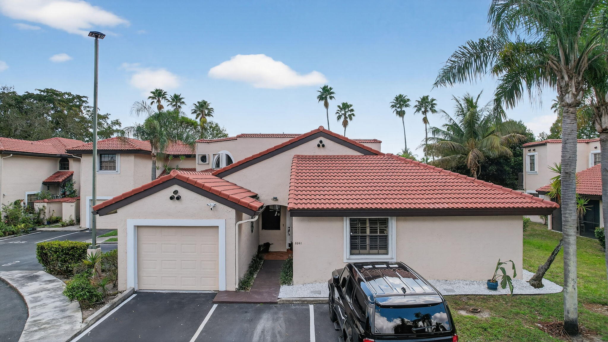 This rarely available 1-story, 3 bedroom 2 bathroom townhome with garage offers extra privacy as it's situated on a corner of a cul-de-sac. Enjoy the convenience of a 1-story layout with vaulted ceilings & an open split floor plan. Kitchen has all newer appliances with granite countertops & wood cabinets. The large primary suite includes walk-in closet, recently renovated bathroom (2023) and sitting area overlooking the covered screened in patio, perfect for enjoying the views of palm trees & expansive grass area. Includes 2 parking spaces, newer water heater & washer, fresh paint. Community amenities include pool, playground, basketball court & event room. Conveniently close to restaurants and shopping while offering the peace of a gated community. HOA covers roof replacement/repairs.