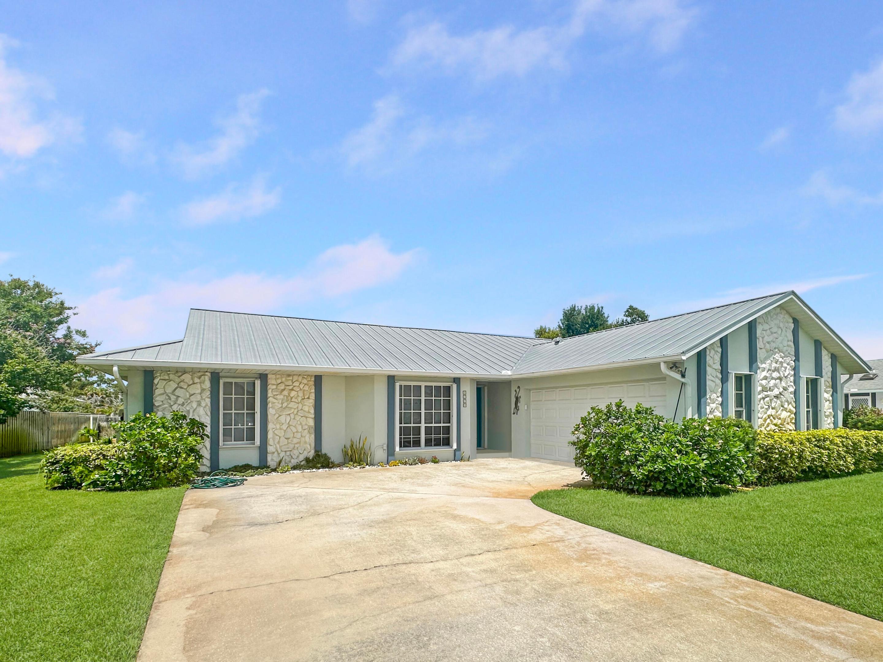 Welcome to the perfect family retreat in one of Northern Fort Pierce's most desirable, well-established neighborhoods! This beautifully maintained single-family home offers a split floor plan featuring three spacious bedrooms and two full bathrooms, ideal for comfort and privacy. The master suite boasts a generous walk-in closet, private pool access, and a serene atmosphere for relaxation. Step into an updated kitchen, complete with modern finishes, that seamlessly connects to a large living and dining area—perfect for family gatherings and entertaining friends. Enjoy the convenience of an inside laundry room, equipped with abundant storage cabinets and a handy wash tub. The home features durable ceramic tile and resilient rubber plank flooring throughout, ensuring both style and practicality. Both guest bedrooms are roomy and share a versatile guest bath that also serves as a cabana bath for poolside convenience.  Step outside to a screened-in patio and sparkling pool, where you'll enjoy Florida living year-round. The .27-acre lot is enhanced with zoned sprinklers for easy maintenance. Additional highlights include CBS construction with a durable metal roof, two-car garage, a new hot water heater, and a new A/C unit.  Conveniently located close to shopping, dining, schools, parks, golf, and major roadways—this move-in ready home is waiting for your family.