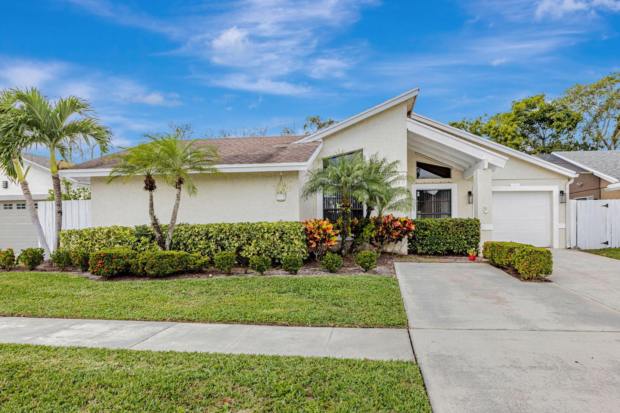 Welcome to your Boca Raton retreat, where everyday living feels a little more like vacation. This remodeled 3-bedroom, 2-bath pool home offers a bright, open layout with soaring ceilings, warm wood-look flooring, and natural light throughout. The heart of the home is the stunning chef's kitchen, featuring white cabinetry, quartz countertops, stainless steel appliances, an oversized island, designer lighting, and a charming coffee bar for slow mornings or quick school-day starts. The living spaces flow easily to the screened pool and covered patio, creating the perfect setting for weekend barbecues, family gatherings, or quiet evenings by the water. The updated primary suite offers a relaxing escape, while two additional bedrooms provide flexible space for family, guests, or a home office.