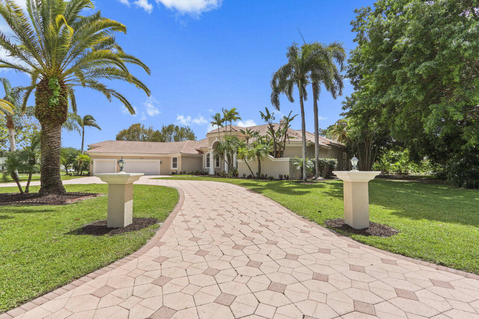 Exceptional Bay Hill Estates residence, offering over 5,300 square feet under air on a premium 1.2-acre lot. This beautifully RENOVATED 5-bedroom, 5-bathroom home, plus two dedicated office spaces, features a highly sought-after single-story layout designed for both comfort and functionality. A grand circular driveway creates a desirable first impression while providing ample parking. Inside, the updated kitchen showcases commercial-grade stainless steel appliances, including a double refrigerator, cooktop, double ovens, quartz countertops, soft-close cabinetry, recessed lighting, and a spacious center island. The expansive in-law suite offers its own private living room, bedroom, and full bath, ideal for guests or multi-generational living. Step outside to an incredible outdoor living space featuring a covered lanai and a fully screened pool and spa area, all overlooking serene lake views. The expansive backyard offers plenty of room to relax or play beyond the pool enclosure. Additional highlights include marble flooring throughout the main living areas, a whole-house generator, and all three AC units replaced in 2020 & 2021. Nestled within a private, gated setting, Bay Hill Estates is an exclusive community of approximately 240 homes, each situated on expansive one-acre homesites surrounded by scenic lakes, canals, and the renowned PGA National Golf Club. Residents enjoy 24-hour manned security, walking paths, and included cable and internet services. Optional membership opportunities at PGA National Resort provide access to world-class golf, tennis, and resort-style amenities. Ideally located just minutes from upscale shopping, dining, cultural attractions, and Palm Beach County's beautiful beaches, Bay Hill Estates offers a perfect blend of privacy, luxury, and convenience. Don't miss out on this exceptional opportunity. Call and schedule your showing today.