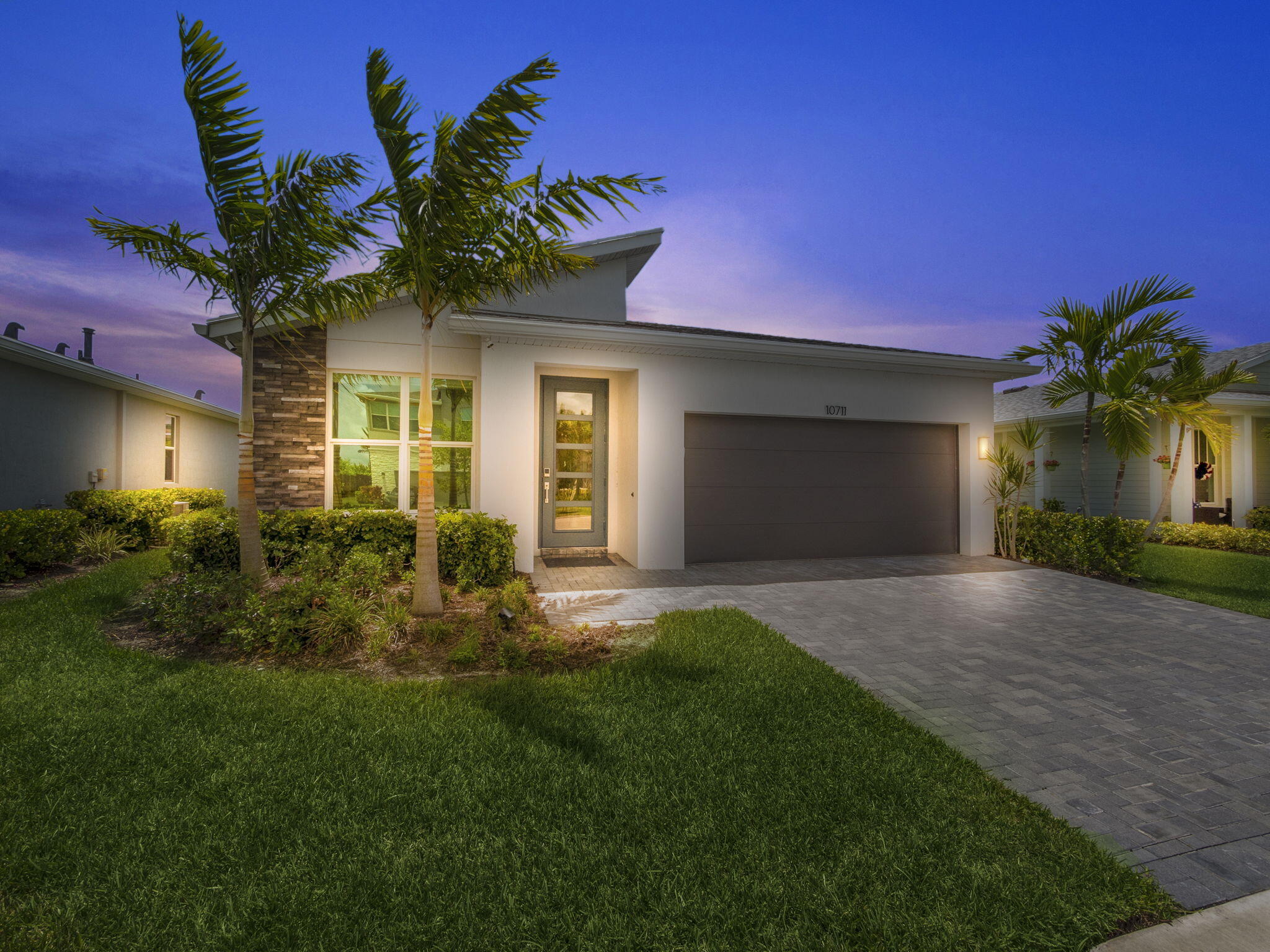 Experience the pinnacle of modern living in this newly built (2022) lakefront pool home situated in the premier Emery at Tradition community. This exquisite 3-bedroom, 2.5-bath residence blends luxury, comfort, and contemporary style with a serene waterfront setting that offers stunning views and a calming ambiance. Inside, the open-concept layout features wood-style tile flooring, abundant natural light, and expansive windows showcasing panoramic views of the lake and custom-designed pool. Elegant contemporary lighting enhances the clean, modern design, while the gourmet kitchen serves as the heart of the home with premium stainless steel appliances—including a gas range—sleek cabinetry, a large quartz island, and a seamless flow into the dining and living areas. The primary suite provides a private sanctuary with captivating lake views, a spacious walk-in closet, and a spa-inspired en-suite bathroom complete with dual vanities, a walk-in shower, and high-end finishes. Two additional bedrooms offer generous space and versatility for family or guests, accompanied by beautifully appointed bathrooms that complement the home's modern aesthetic.

Step outside to your own private oasis, where a custom pool and spa crafted by Pools by Greg and enclosed by Pioneer Screen II invite relaxation against the stunning lakefront backdrop. Complete impact glass provides added peace of mind, while a long list of thoughtful upgrades elevates the living experience even further. These include Lutron smart shades by Budget Blinds, upgraded bathroom glass enclosures, custom storage systems such as an IKEA primary closet and Container Store pantry and hall solutions, a stylish glass pantry door, and designer chandeliers throughout the dining room, bedrooms, and den. Additional enhancements include custom media cabinetry in the living room and den, professional front and rear landscaping with outdoor lighting, home automation features, a remodeled powder room, upgraded cabinet hardware, an upgraded dishwasher, and a new washer and dryer. Located in one of Tradition's most sought-after communities, this home provides access to a clubhouse, community pool, and is just minutes from the vibrant Tradition Square, offering shops, dining, entertainment, and year-round events.
