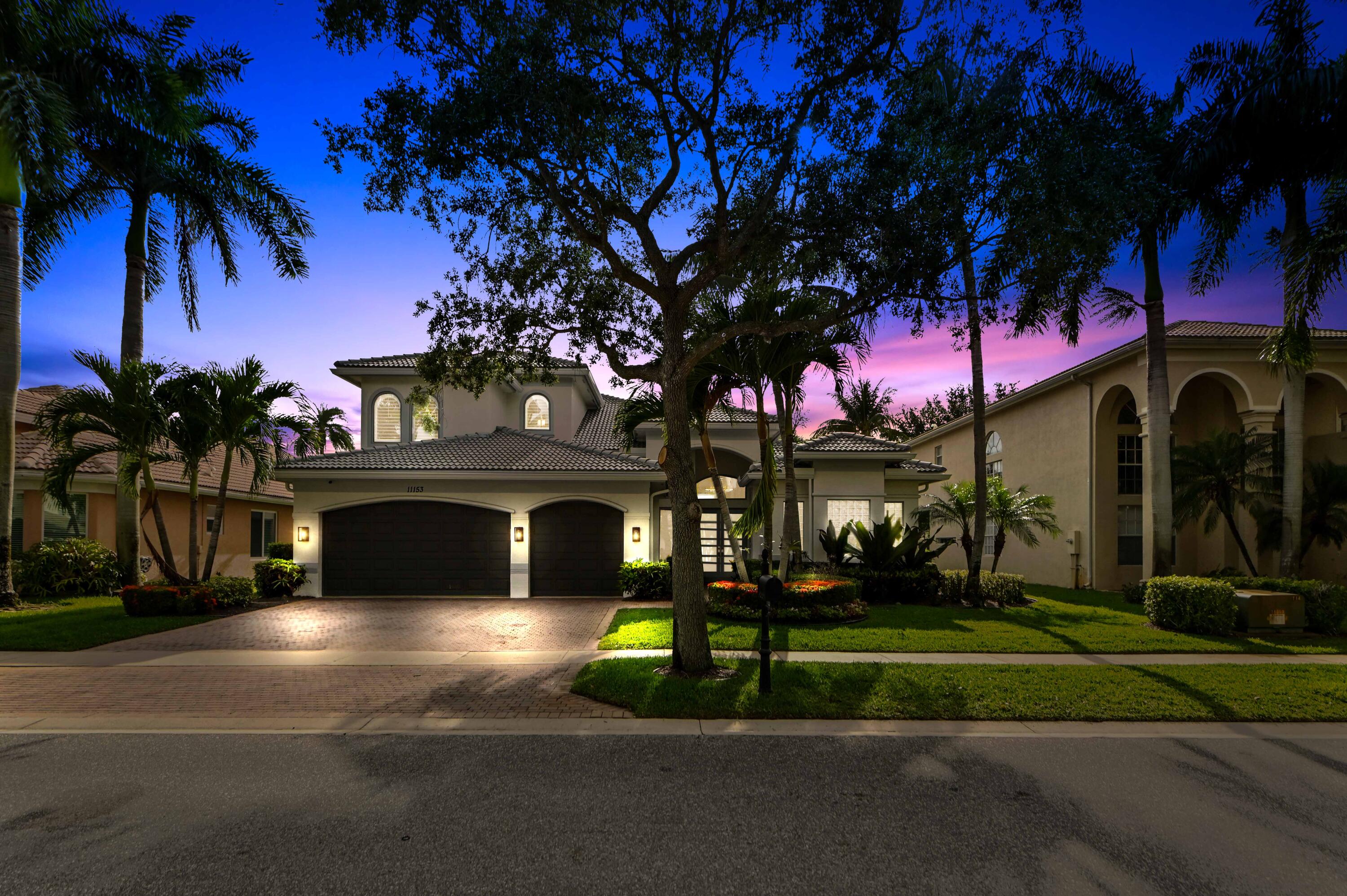 Welcome to a beautifully updated & waterfront residence in the desirable Boynton Beach community of Canyon Isles. Set among lush tropical landscaping and peaceful lake views, this home immediately captures the feel of South Florida living. The home makes a striking first impression with its fresh exterior presence, brand new roof, full impact windows & doors, spacious driveway, and inviting entry, offering a warm blend of curb appeal, privacy, and everyday comfort in a well-kept neighborhood setting.  Inside, the home feels bright, open, and sophisticated with soaring ceilings, large windows, plantation-style shutters, and warm wood-look flooring that flows through the main living areas. The home also boasts the primary suite & 3 guest bedrooms on the first floor along with 3 full bathrooms. The second floor includes a huge loft space, full bedroom & bathroom.  The living room offers an elegant focal point with a sleek media wall, while the fully updated kitchen brings a clean modern feel with glossy white cabinetry, quartz-style countertops, a stylish backsplash, and warm lower cabinetry that adds texture and contrast. All bathrooms have been newly updated adding a fresh, spa-like touch with contemporary tilework, a glass-enclosed showers, and modern finishes.    Outside, overlooking the beautiful lake, is an entertainers dream with a free-form pool & spa that has been newly resurfaced and upgraded tile added, travertine decking, summer kitchen, and separate screened patio area.  Thoughtful upgrades make this home even more appealing, including a new roof with spray foam insulation, impact windows, 3 new AC units, all new bathrooms and a full home generator with a 500 gallon propane tank, giving buyers confidence and move-in-ready convenience. With large bright bedrooms, generous closet space, refined finishes, and a serene Boynton Beach location close to shopping, dining, recreation, and everyday essentials, this home offers an enticing opportunity to enjoy comfort, style, and the relaxed lifestyle South Florida is known for.