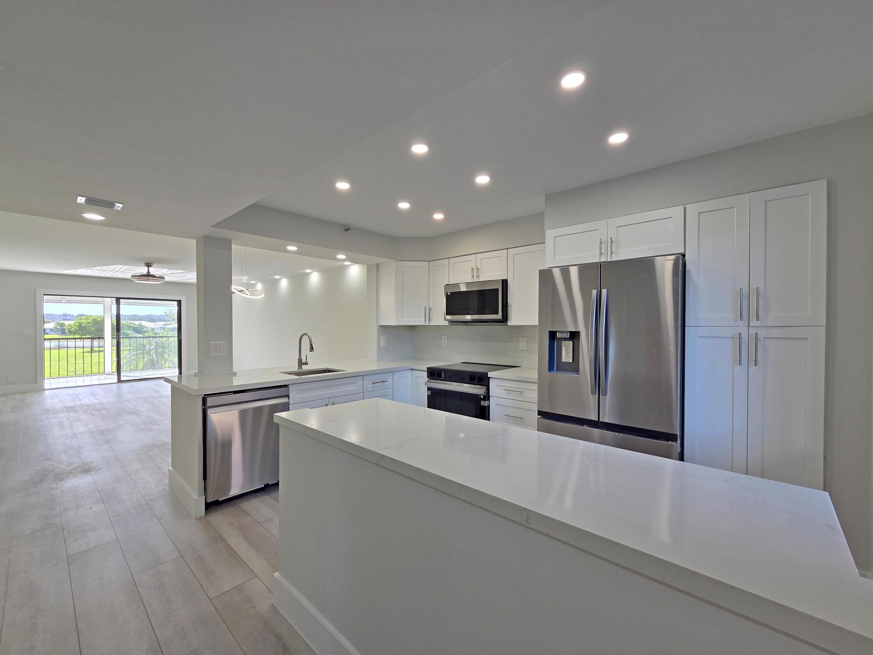 If you are looking for a completely renovated, 2-bedroom, 2-bathroom Lancaster model condo, this home is for you! Enjoy the countless amenities of the Huntington Lakes lifestyle community at your fingertips. This home features a beautiful, open-concept white kitchen with recessed lighting, new stainless steel Samsung appliances, a breakfast island, and a large pantry. The living room boasts smooth ceilings with retractable fans and soffit lighting. The master suite faces the sunrise and includes two custom-made closets and a stylish new bathroom with an LED mirror. Additionally, there are spacious guest quarters with a private entry. Other upgrades include a separate laundry room with a new LG washer and dryer, a 2025 AC unit, and a new water heater. The flooring is a premium combination  of waterproof vinyl and porcelain tiles. The owner is open to negotiating buyer requests for minor alterations. You will be just a 2-minute walk from the fabulous, newly renovated 50,000-square-foot grand clubhouse, which features an Olympic-sized indoor pool, live shows, movies, and a broad array of activities to suit every taste. Amenities include pickleball courts, nine tennis courts, saunas, art studios, game rooms, and a gym. There is also a heated Section 3 satellite pool located just behind the building.  The property is located in Delray Beach, a gem of South Florida. The city is famous for its trendy downtown with upscale shops, fine dining, nighttime entertainment, and the incomparable beauty of award-winning beaches, all conveniently located within 6 miles.