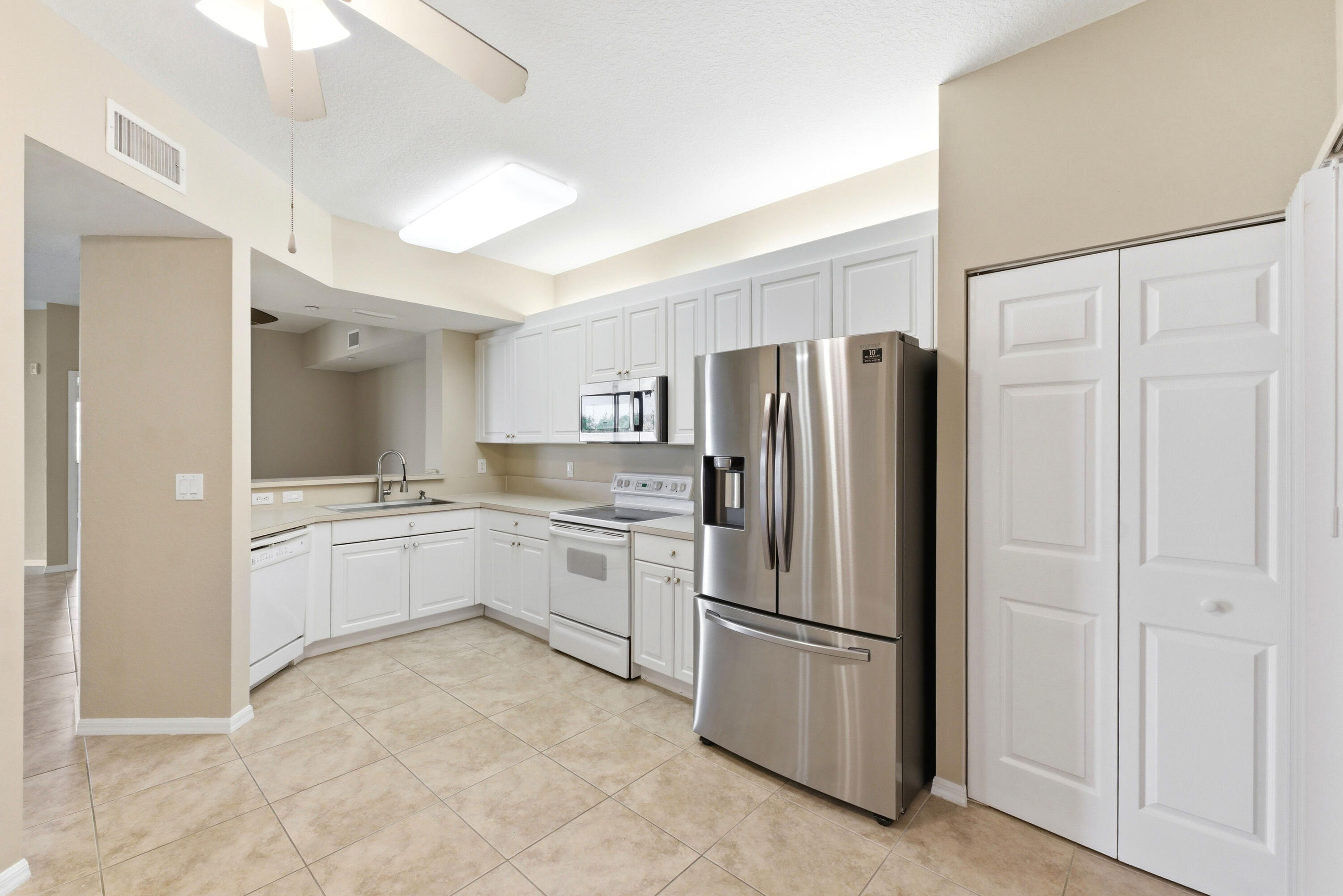 Move-in ready 55+ first-floor residence in the sought-after gated community of Yardley at Tamarac. Offering approximately 1,500 square feet of living space, this spacious home feels more like a private house, complete with its own front-yard entrance. Freshly painted  featuring a newer A/C unit, brand-new luxury vinyl flooring and tile throughout, No Carpet. Enjoy breathtaking lake views from nearly every room, creating a peaceful and relaxing atmosphere. Enjoy the security of a gated community along with an impressive array of resort-style amenities, including a sparkling pool, cabana, shuffleboard courts, tennis and pickle-ball courts, and a vibrant social calendar with entertainment and community activities.
