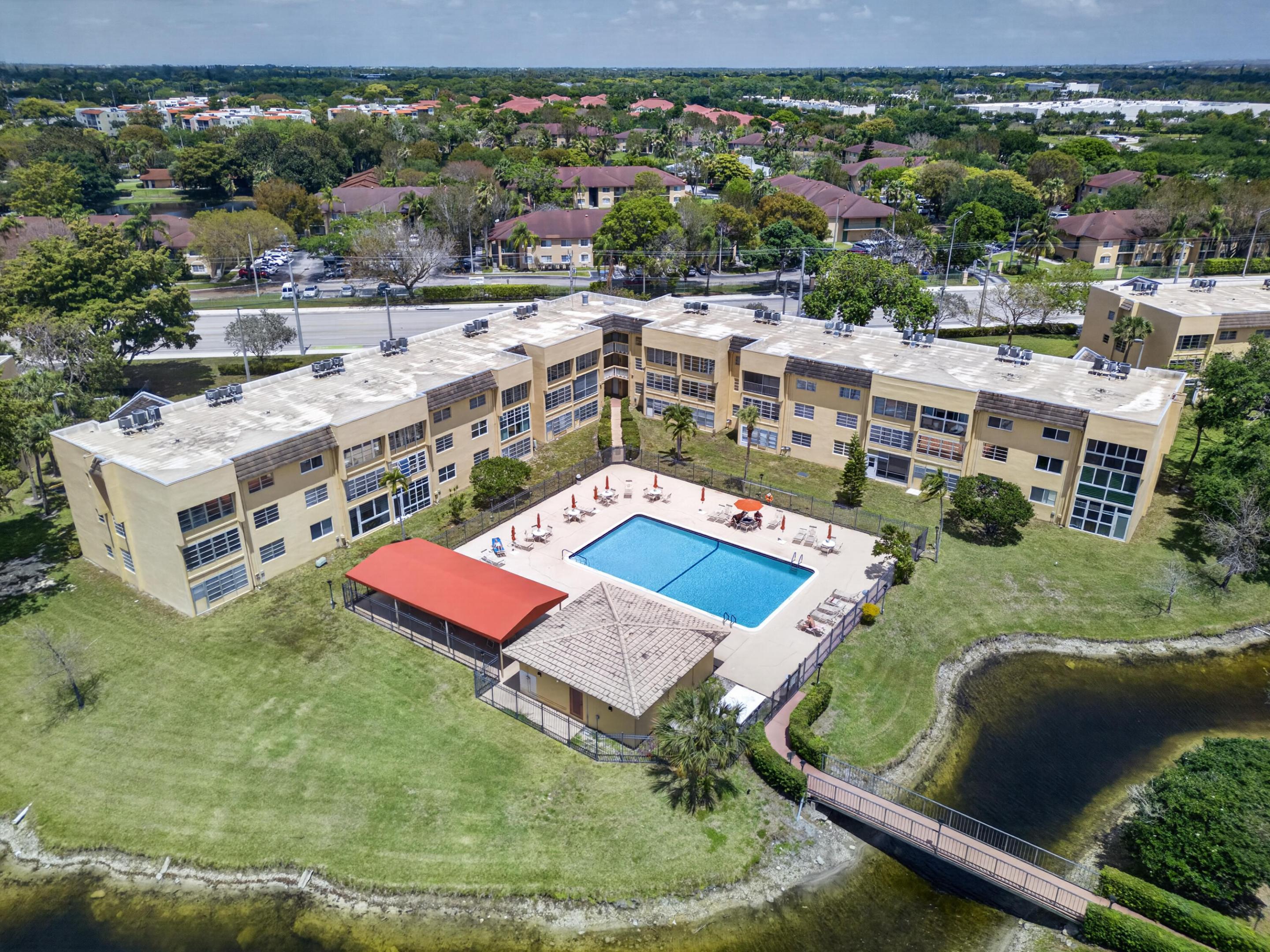2 Bed/2 Bath corner unit steps to the pool with lake & pool views in the 55+ active adult community of Bermuda Club in Tamarac! Great opportunity to make this unit your own with tons of natural light, walk-in closets in both bedrooms, and over 1,000 square feet of living space. Master Bedroom features an ensuite bathroom w/oversized shower and space for a dual sinks. Kitchen & entryway features porcelain tile floors. Enjoy an enclosed patio overlooking the lake and pool. Community amenities include 4 pools, tennis courts, mini golf, and a clubhouse with a library, ballroom, updated fitness center & movie theater. HOA covers cable, reserve funding, exterior insurance and pest control. Conveniently located near major transportation, bus routes, shopping centers, restaurants, and more!