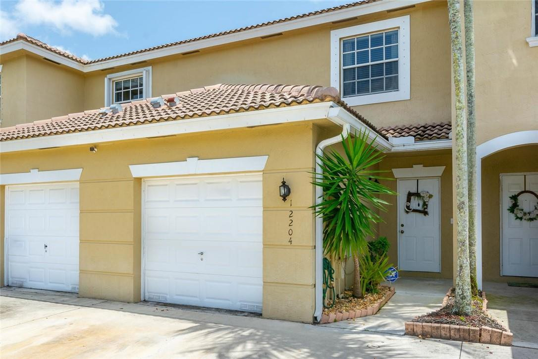 This ready to move into 2/2.5 townhouse with garage has tumbled travertine marble floors on 1st floor & all baths. Travertine flows outside to the exterior patio for Fla entertaining which adjoins to an extended brick paver patio providing fabulous outside entertaining and view of lake to the east. Lovely updated kitchen has s/s appliances, brand new Whirlpool digital programmable stove/oven, marble backsplash and granite counters with snack bar. Marble half bath has designer flair. All baths have bronze hardware. Home tailored with 5" crown molding and baseboards. Living room boasts a gorgeous stack stone accent wall. Stairs and second floor is hardwood. No carpet here! A/C is 2016. Hurricane shutters in the garage. Plz see Supplement Remarks. Both full baths are also travertine marble with all wood cabinetry. 2-car driveway + garage, lots of guest parking close by. Community pool, tennis, clubhouse, HOA paints exterior and provides basic cable and internet. Low HOA fee.
