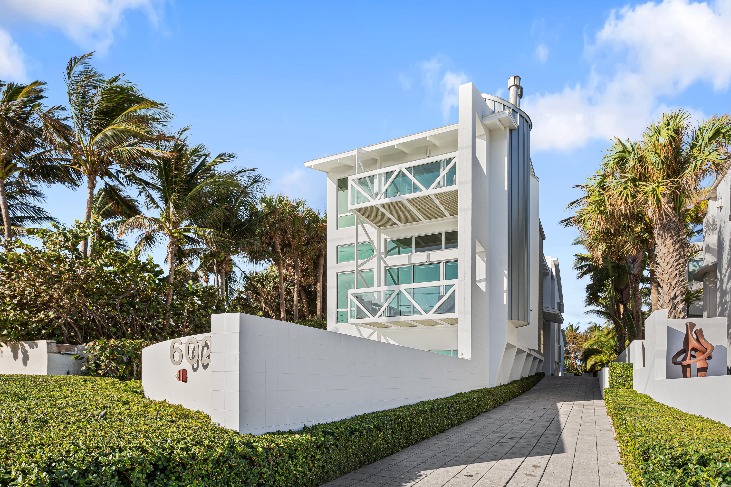 Architecturally brilliant and newly renovated, this ultra-luxurious tri-level residence combines panoramic ocean views with luxury, elegance and personal privacy. Details include a full-floor master suite, guesthouse, great room with sleek epicurean kitchen, media room with kitchenette and cabana bath, steel spiral staircases, elevator, and lap pool with water features. North Ocean Boulevard, Delray Beach, Florida. Historic Delray Beach is a beautifully preserved oceanfront community in the heart of South Florida's famed Gold Coast. Ensconced in an exclusive island-side enclave, this ultra-luxury residence is directly across the street from pristine ocean beachfront and within walking distance of the eclectic shops, cafes and restaurants that line vibrant Atlantic Avenue.

PROPERTY:
On a fenced quarter-acre, framed by specimen palms and manicured hedges, a brick motor court introduces this stunning contemporary estate delivering a distinct sense of place. In the newly landscaped backyard, covered and uncovered patios and the new outdoor kitchen offer ample spaces for entertaining. Custom-designed water elements include a covered heated lap pool flanked by a spa and a spillover waterfall, along with an outdoor shower, all recently updated.

RESIDENCE:
An architectural triumph that defines elegance, luxury and privacy, this artfully designed and recently renovated five-bedroom masterpiece, with 9197± total square feet, encapsulates a striking industrial urban aesthetic with lyrical interior curves. Contrasting a dynamic, melodious fluidity and a sense of drama that surprise and delight from every vantage point, the three-story foyer and impressive glass-and-steel spiral staircase are crowned by a metal-clad ceiling. From the first-level, comprising a media room, with a kitchenette and cabana bath, and guest bedrooms with renovated ensuite bathrooms, the staircase ascends to the main floor. Showcasing a gas fireplace designed by Dominique Imbert, the chic great room opens to an oceanfront covered patio. Just adjacent, the formal dining area is served by a gourmet kitchen with glass-faced cabinetry and professional-grade stainless appliances. A hallway with glass-shelved built-in cabinetry is a prelude to the voluminous library, the steel spiral staircase to the third-floor, and an outdoor walkway to the private guesthouse with a sitting room and ensuite bedroom. A luxurious sanctuary, the magnificent primary suite occupies the entire third level. The expansive bedroom, with a sitting area is enhanced by a gas fireplace, a metal pitched ceiling, and aluminum shuttered sliding doors that access the oceanfront balcony. The suite comprises custom-fitted walk-in closets and a celadon-tiled bathroom with a black-accented dual-sink vanity, jetted spa tub and walk-in shower. Completing the layout are a laundry, industrial-style elevator with new technology, and  an airconditioned two-bay garage. New amenities include a full-house generator, security and camera systems, outdoor speakers, hurricane-rated glass, motorized shades, and two air-conditioning units, with all six equipped with expensive UV light purifiers and electric static air filters to insure the cleanest possible air throughout the home. With the serenity of seemingly endless ocean views and immediate entrée to the beach, this ultra-contemporary residence and guesthouse embody the energy and ambiance so essential to an exceptional South Florida lifestyle. The creative use of spaces topped by volume ceilings, open galleries, an atrium, window-walls of glass, designer fireplaces, new wood and porcelain flooring, decorator-curated lighting and fiber-optic exterior lighting maximize the estate's emotional impact.

The information herein is deemed reliable and subject to errors, omissions or changes without notice.  The information has been derived from architectural plans or county records. Buyer should verify all measurements.

DISCLAIMER: Information published or otherwise provided by the listing company and its representatives including but not limited to prices, measurements, square footages, lot sizes, calculations, statistics, and videos are deemed reliable but are not guaranteed and are subject to errors, omissions or changes without notice. All such information should be independently verified by any prospective purchaser or seller. Parties should perform their own due diligence to verify such information prior to a sale or listing. Listing company expressly disclaims any warranty or representation regarding such information. Prices published are either list price, sold price, and/or last asking price. The listing company participates in the Multiple Listing Service and IDX. The properties published as listed and sold are not necessarily exclusive to listing company and may be listed or have sold with other members of the Multiple Listing Service. Transactions where listing company represented both buyers and sellers are calculated as two sales. The listing company's marketplace is all of the following: Vero Beach, Town of Orchid, Indian River Shores, Town of Palm Beach, West Palm Beach, Manalapan Beach, Point Manalapan, Hypoluxo Island, Ocean Ridge, Gulf Stream, Delray Beach, Highland Beach, Boca Raton, East Deerfield Beach, Hillsboro Beach, Hillsboro Shores, East Pompano Beach, Lighthouse Point, Sea Ranch Lakes and Fort Lauderdale. Cooperating brokers are advised that in the event of a Buyer default, no financial fee will be paid to a cooperating Broker on the Deposits retained by the Seller. No financial fees will be paid to any cooperating broker until title passes or upon actual commencement of a lease. Some affiliations may not be applicable to certain geographic areas. If your property is currently listed with another broker, please disregard any solicitation for services. Copyright 2022 by the listing company. All Rights Reserved.