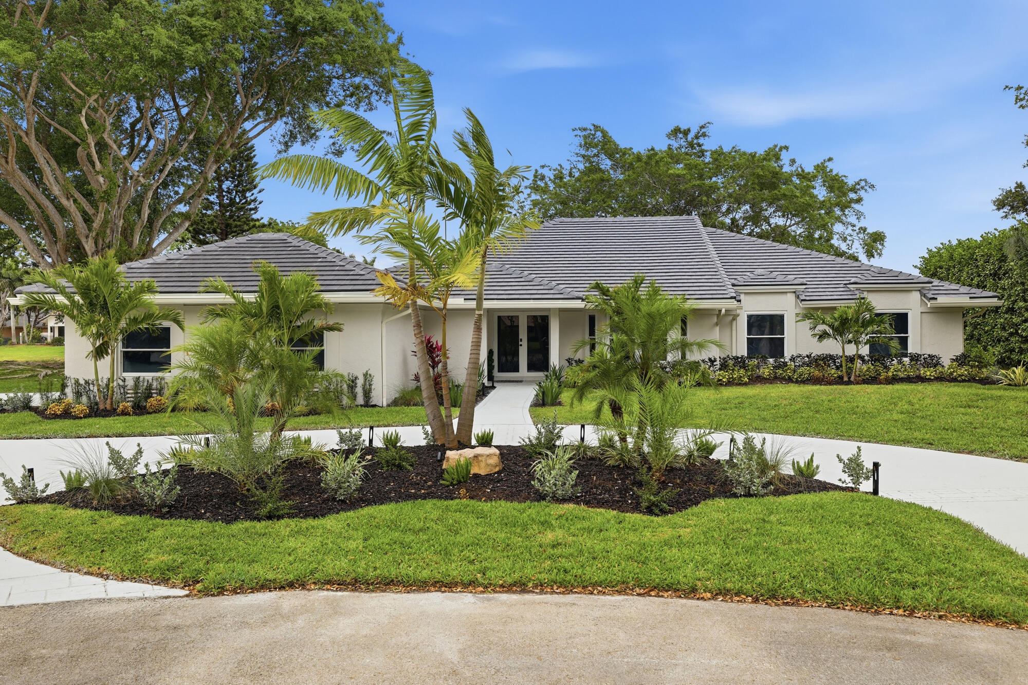 Welcome to 7411 Dover Lane, a beautiful, fully renovated five bedroom, four and a half bathroom waterfront estate tucked away on a quiet cul-de-sac in the sought after Cypresshead community of Parkland. Set on a rare three-quarter acre lot with long water views, this 3,337 square foot refined, move-in ready home blends thoughtful design, premium finishes, and recent upgrades to deliver a turnkey lifestyle in one of South Florida's most desirable neighborhoods. As every major upgrade has already been completed, you will be able to enjoy the home from day one. From the moment you arrive, the home presents with intention. Professionally designed landscaping, custom lighting, and an expansive setback create a strong sense of arrival, while the oversized lot delivers a level of space and privacy rarely found in the area. This lot is a rare find in Parkland, offering exceptional space, privacy, and a peaceful waterfront backdrop that creates a true sense of retreat.               Inside, the residence has been completely reimagined with a focus on clean lines, quality materials, and functional design. Custom doors, detailed trim work, and fully built-out closets in every bedroom elevate the entire interior. The layout is open yet defined, with multiple living and entertaining spaces that naturally draw your attention toward the water.  At the center of the home is a thoughtfully designed, chef-level kitchen that balances form and function.                Outfitted with GE profile double ovens, double sinks, and double dishwashers, along with a 48-inch built-in refrigerator, Wolf induction 36-inch cooktop and Wolf microwave drawer, the space is designed to perform during both everyday use and large-scale entertaining.                The primary suite serves as a true retreat, complete with a stunning custom marble bathroom with a spa-like feel and a level of finish consistent with high-end custom homes. Secondary bathrooms carry the same material quality and attention to detail, creating a cohesive design throughout.                  Step outside and the resort style backyard truly comes to life. The pool has been fully refinished with new Diamond Brite, glass tile, and updated lighting, creating a clean, modern look. A brand new 2026 screen enclosure with picture window panels frames the water views beautifully while maintaining comfort and openness. The cul-de-sac location combined with the waterfront setting provides a quiet, private backdrop that is difficult to replicate.   Beyond aesthetics, this home delivers where it matters most. A brand new 2026 roof, full impact windows and doors, two new Rheem air conditioning systems, a new 80 gallon water heater, new gutters, whole house water softener and filtration, sprinkler pump and epoxy garage provide long-term durability and peace of mind.               Cypresshead is known for its tree lined streets, oversized lots, and welcoming community atmosphere.  In Cypresshead, where lot size and location drive long-term value, opportunities that combine waterfront positioning, nearly an acre of land, full hurricane protection, a chef-level kitchen, and a complete top-to-bottom renovation are extremely limited. Residents can further enjoy convenient access to parks, shopping, dining, and major roadways, making it easy to enjoy everything Parkland and the surrounding area have to offer.                7411 Dover Lane offers a level of finish, privacy, and readiness that stands apart from typical renovated homes in this market. Schedule your private tour today and experience everything this exceptional Parkland property has to offer.