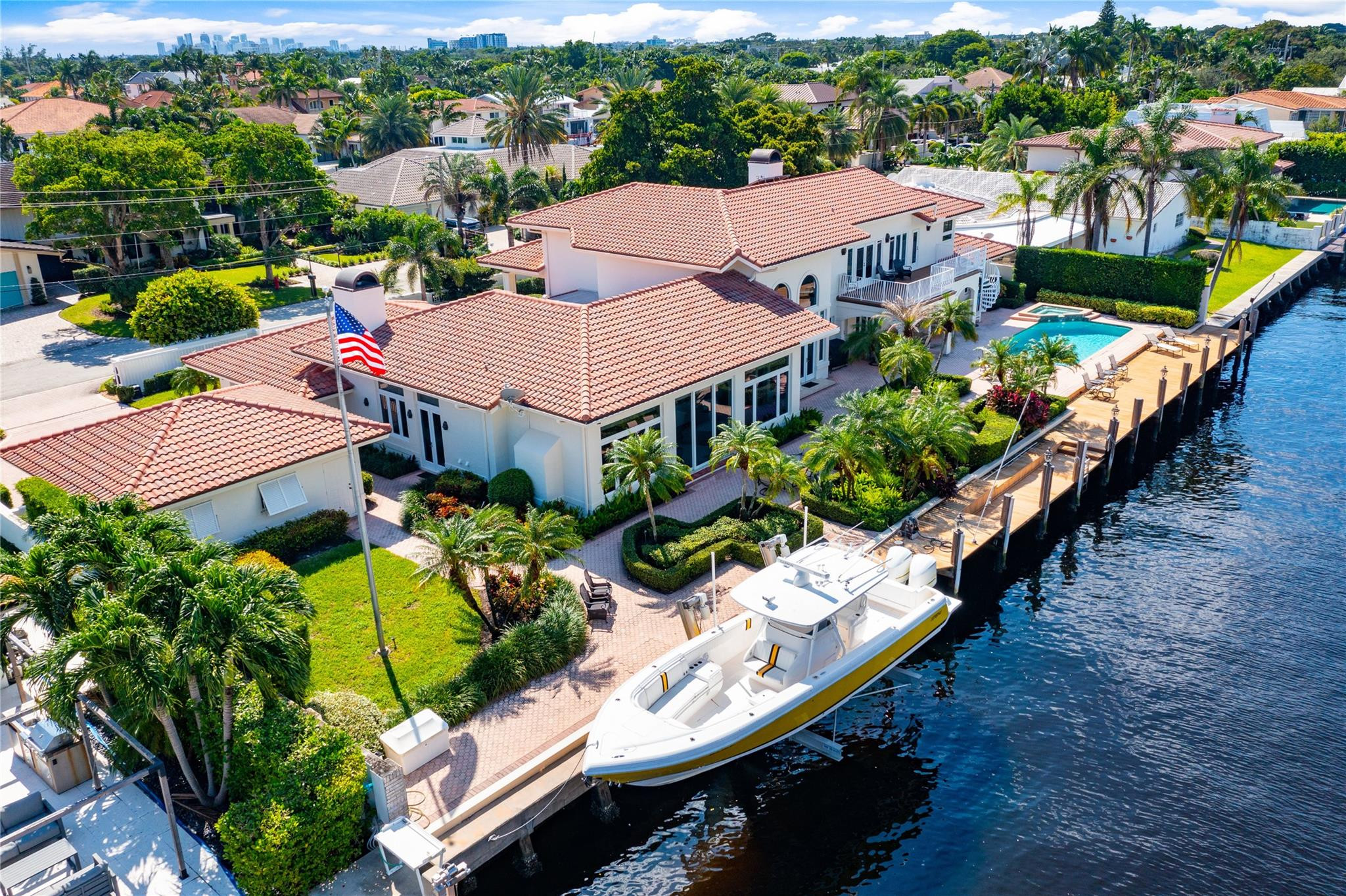This fabulous 5 bedroom and 4.1 bath estate is on a gated double lot. With 170 feet on the water. Built in 1990 with volume ceiling throughout. Gourmet kitchen with Sub Zero refrigerator and freezer. If you love to entertain you will love this open floor plan. All hurricane impact windows and doors throughout.  This home has two family rooms and two fireplace's. You can use one side of the home for just the children or use as a in laws quarters. Beautiful private office is on the main level. Private Master bedroom suite, is on the second floor, over sized walk in closet and fireplace. luxurious Master bathroom with sauna. Enjoy beautiful views of the intracoastal from balcony. 20,000 lbs boat lift, Summer kitchen bar, salt water heated pool and a 4 car garage.