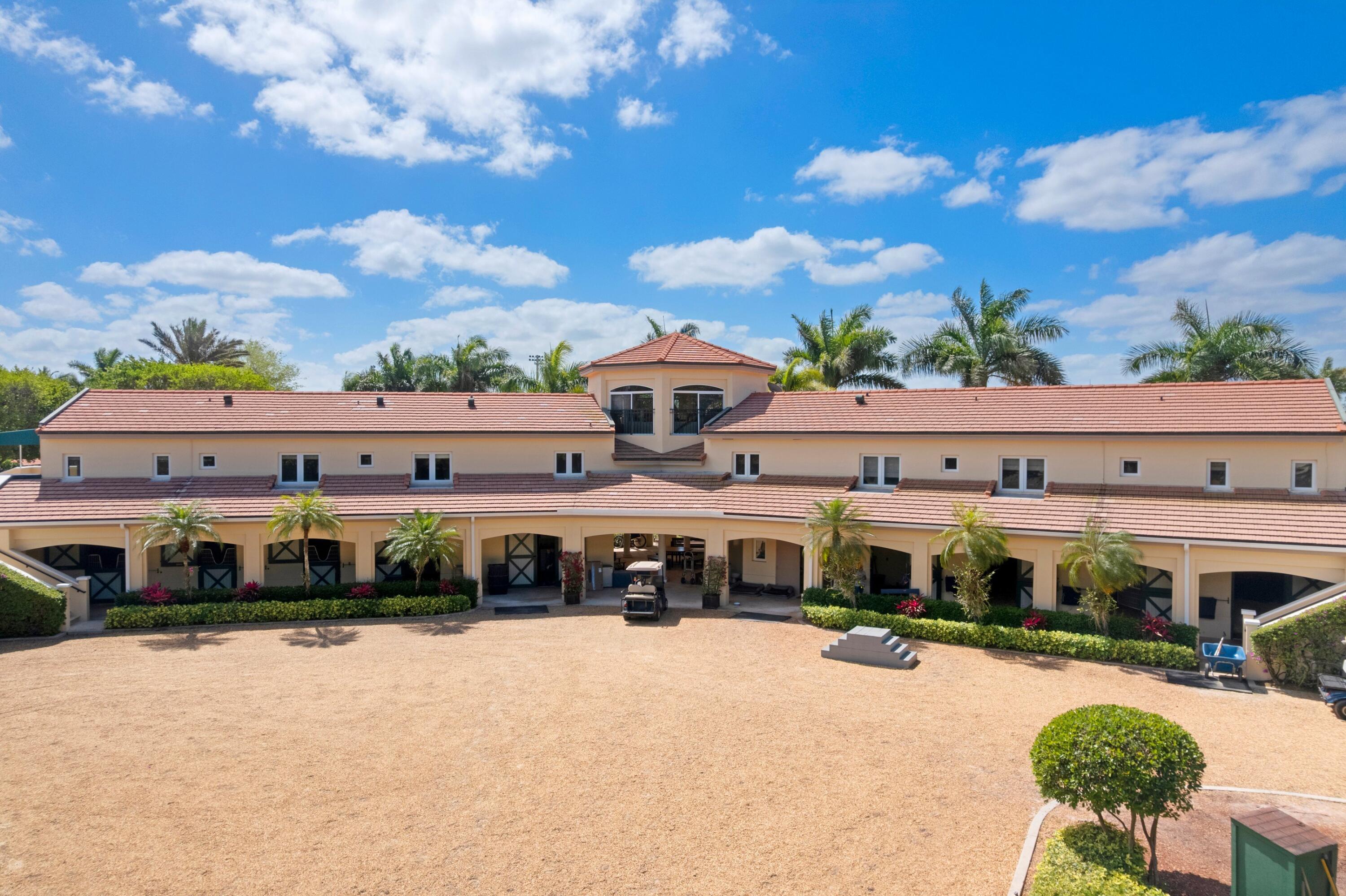 Rare opportunity to own one of the most intriguing equestrian farm locations just steps away from the world-renowned Winter Equestrian Festival in Wellington. Perfectly positioned for riders, trainers, and investors alike, this exceptional property offers both convenience and a fully equipped, income-producing setup on just over 6 acres. Designed with functionality and comfort in mind, the farm features two well-appointed living quarters above the barn. Suite One offers a spacious 3-bedroom, 2.5-bath layout, while Suite Two includes 4 bedrooms and 2 bathrooms, highlighted by a convenient Jack-and-Jill design—ideal for staff, guests, or rental income. The barn is equipped with 16 stalls and 4 wash stalls, complemented by a fly spray system to ensure optimal care and comfort for the horses. The property includes nine well-maintained paddocks, all supported by water cannon irrigation for efficient and consistent coverage. Equestrian amenities are second to none, featuring a professional riding arena along with an oversized grass warm-up/cool-down arena positioned at the front of the property for easy access and presentation. Additional features include a 4-horse circular  (walking pen), a large garage-style storage facility, and two additional storage sheds to accommodate all equipment and operational needs. For a unique elevated perspective, the property also offers an upper-level viewing gazebo, perfect for observing training sessions or enjoying the tranquil farm setting. This is a rare blend of location, infrastructure, and versatility—ideal for seasonal use, full-time operations, or investment in one of the most sought-after equestrian destinations in the world.