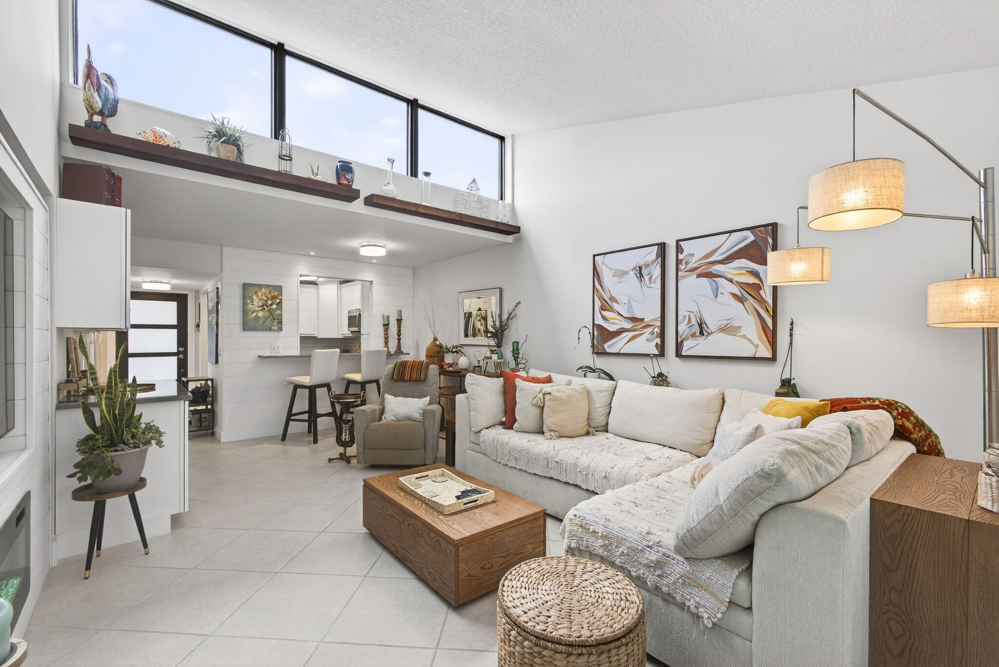 Welcome to your newly designed villa with skylights, impact glass throughout & a modern elegance that makes it a standout in the community. Recent upgrades have opened up, brightened & transformed this 940 sq ft floor plan. The kitchen features brand-new Shaker cabinets & stainless-steel appliances. The wall was opened up to the living room, with countertop space expanded, unifying the living space. In the living room, the wall-to-wall skylight brings in fantastic natural light. A dry bar has been added. Barn doors can be opened up for entertaining & closed for privacy in the convertible den between the living room & half bath. The primary bathroom has brand-new tiling, fixtures, vanity & LED-framed mirror. The half bath has a brand-new vanity & cabinets. Tile floor throughout; freshly painted; new water heater. Reverse osmosis system for clean drinking water.  Full-size new LG brand W/D in the patio, which features a back door that is convenient for a walk to the pool nearby. Two trees & beautiful landscaping highlight the outside greenery. Boundbrook is a well-maintained 55+ community situated close to the highways & Palm Beach Airport, as well as shopping on 10TH AVE & CONGRESS AVE. This is a quiet neighborhood & the villas offer more privacy than condo living. Close to Publix; downtown Lake Worth & downtown West Palm Beach are both nearby as well. There is a 1-car maximum for this unit.
