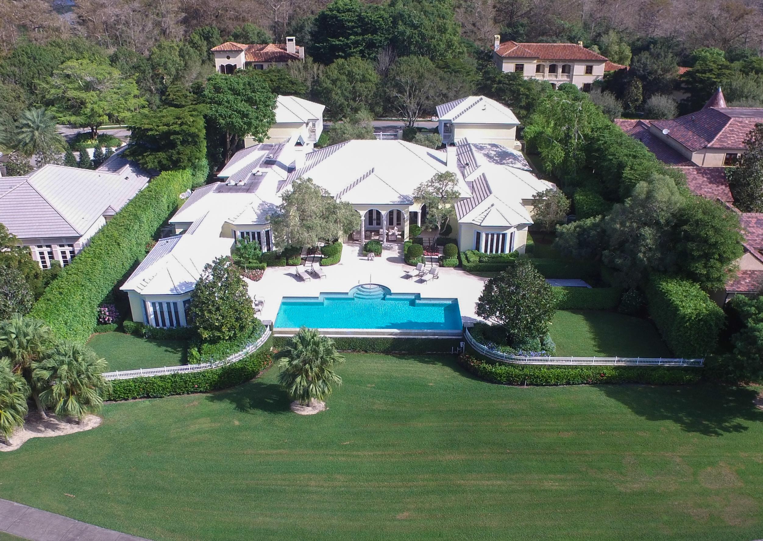 This sprawling property is marked by an elegant style with a subtle tropical feel, and is one of the finest estates Palm Beach Polo Golf and Country Club has to offer. Rarely does an exquisite home of this magnitude become available in the elite gated Bridle Path neighborhood, near the area’s world famous equestrian festivities. 

Upon entering the gates to the property, the stately motor court features two spacious garages built to accommodate four vehicles. Expertly designed by Laszlo Wagner of the Landfall Group for the current owner, the main house provides over 9,000 feet of air-conditioned living space. The home boasts a pleasant mix of limestone and wormy chestnut floors, neutral decor, formal living and dining rooms, 2 fireplaces, and a remarkable cherry paneled library. The well-equipped kitchen features two dishwashers, a 6 burner gas stove with a large dual fuel range, a double wall oven, and a Butlers' pantry. Nestled on the second floor are two roomy guest suites, each with their own morning kitchen, large bath, and walk-in closet.

The charming guest cottage, which overlooks the infinity pool, hot tub, and the 12th hole of the Cypress golf course, features a kitchenette and a full bath. The space is perfect for a home office, guest cottage, or exercise studio.