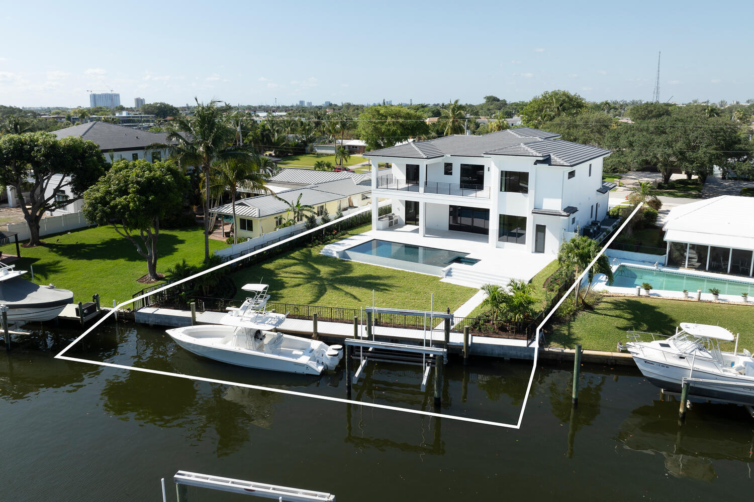 Immerse Yourself in Waterfront Luxury: Exquisite 5-Bedroom, 5.5-Bathroom 3.5 Car Garage, New Construction Awaits
This stunning new build masterpiece, boasting a spacious 4,612 sq ft of living space on a sprawling 12,600 sq ft property, redefines waterfront living. Breathtaking water views, expansive living areas, and top-of-the-line finishes create a haven designed for luxurious living and effortless entertaining. As you arrive, the dramatic marble driveway sets the stage for the grandeur that awaits. Step inside and be greeted by the warmth of 9.5'' engineered wood floors flowing seamlessly throughout the downstairs living areas. The heart of the home lies in the gourmet kitchen, a chef's dream. Custom white shaker cabinetry provides ample storage, while full marble backsplashes add a a touch of elegance. Prepare culinary masterpieces with a powerful Wolf 48" dual fuel range, a whisper-quiet Sub-Zero 72" refrigerator and two Cove dishwashers. An oversized island with waterfall edge Arasbescato Corchia Honed marble countertops offers additional prep space and a perfect spot for casual gatherings, all illuminated by beautiful cabinet lighting.
Ascend the staircase, where the beautiful wood floors continue, and arrive at the private sanctuary of the master suite. Unwind in the morning bar before stepping out to the private balcony and soaking in the mesmerizing water views. The luxurious bathroom boasts his and hers walk-in closets, a three-head shower with a handheld sprayer, and a freestanding soaking tub, all finished with high-quality Blizzard marble countertops.
This exceptional home caters to everyone's needs. A downstairs queen suite with a private bathroom offers a comfortable haven for guests, while additional bedrooms upstairs boast ensuite bathrooms and large closets. Some even enjoy access to a balcony overlooking the pool and water, further blurring the lines between indoor and outdoor living. Unmatched convenience awaits. Two laundry rooms, one on each floor, are equipped with washer and dryer sets (the upstairs laundry room features two sets!). An elevator ensures effortless accessibility throughout the home, and the spacious 3-car garage with 12' ceilings allows for car lifts, a dream come true for car enthusiasts. Plus, a 6-zone Sonos system lets you control music throughout the home, while surround sound in the living room creates a cinema-like experience. Venture outside to your private oasis.  Relax by the sparkling, heated saltwater pool and spa, prepare culinary delights in the summer kitchen, or rinse off under the outdoor shower.  The expansive 12,600 sq ft lot provides ample green space for family fun, while boaters will cherish the private dock with a 24,000 lb. boat lift, offering direct ocean access. This magnificent waterfront estate is a rare gem, offering unparalleled luxury, seamless indoor/outdoor living, and top-of-the-line amenities. It's a dream home waiting to be yours.