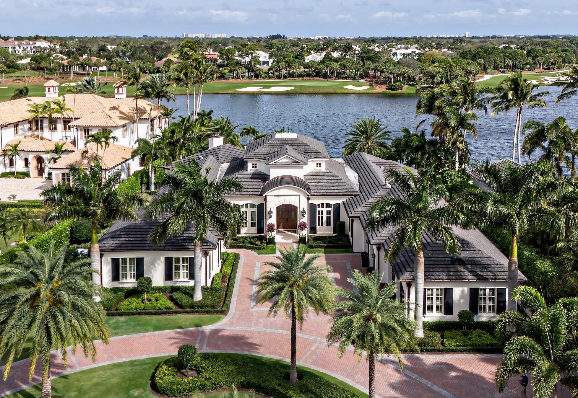 Presenting an unparalleled waterfront residence on a spectacular .8 acre lakefront lot within the prestigious Loxahatchee Golf Club. This sprawling 6,355 square foot single-story estate has been masterfully rebuilt in 2020, offering a total of 9,150 square feet of luxurious living space designed for those who appreciate the finer things in life.

This exquisite home boasts an open floor plan that seamlessly blends indoor and outdoor living. The heart of this estate is a chef's dream, an oversized kitchen equipped with high-end gourmet appliances, perfect for culinary exploration. The adjoining wine room can house over 450 bottles, ensuring every occasion is well catered for.

SEE MORE Accommodations include two master suites and three generously sized bedrooms as well as 6.5 lavish bathrooms. The home also features a his and her office, providing ample space for professional activities and creative endeavors. The custom wood beam detail in the family room ceiling is a testament to the unique architectural design that spans throughout the residence.

Step outside to the breathtaking outdoor living area, complete with a living space, a cozy fireplace, and a fully equipped outdoor kitchen. The amazing pool, spa, and fire pit overlook the tranquil waters, making it an ideal setting for entertaining and relaxation.

Situated on the most desirable lot in The Loxahatchee Club, the property offers long and wide views of the pristine lake, making it one of the most incredible estate homes ever to be sold in this community.

This home not only promises a serene and luxurious lifestyle but also an investment in exquisite craftsmanship and architectural finesse. Make 236 Locha Drive your new sanctuary, where every detail is a stroke of genius and every day is a glimpse of paradise.