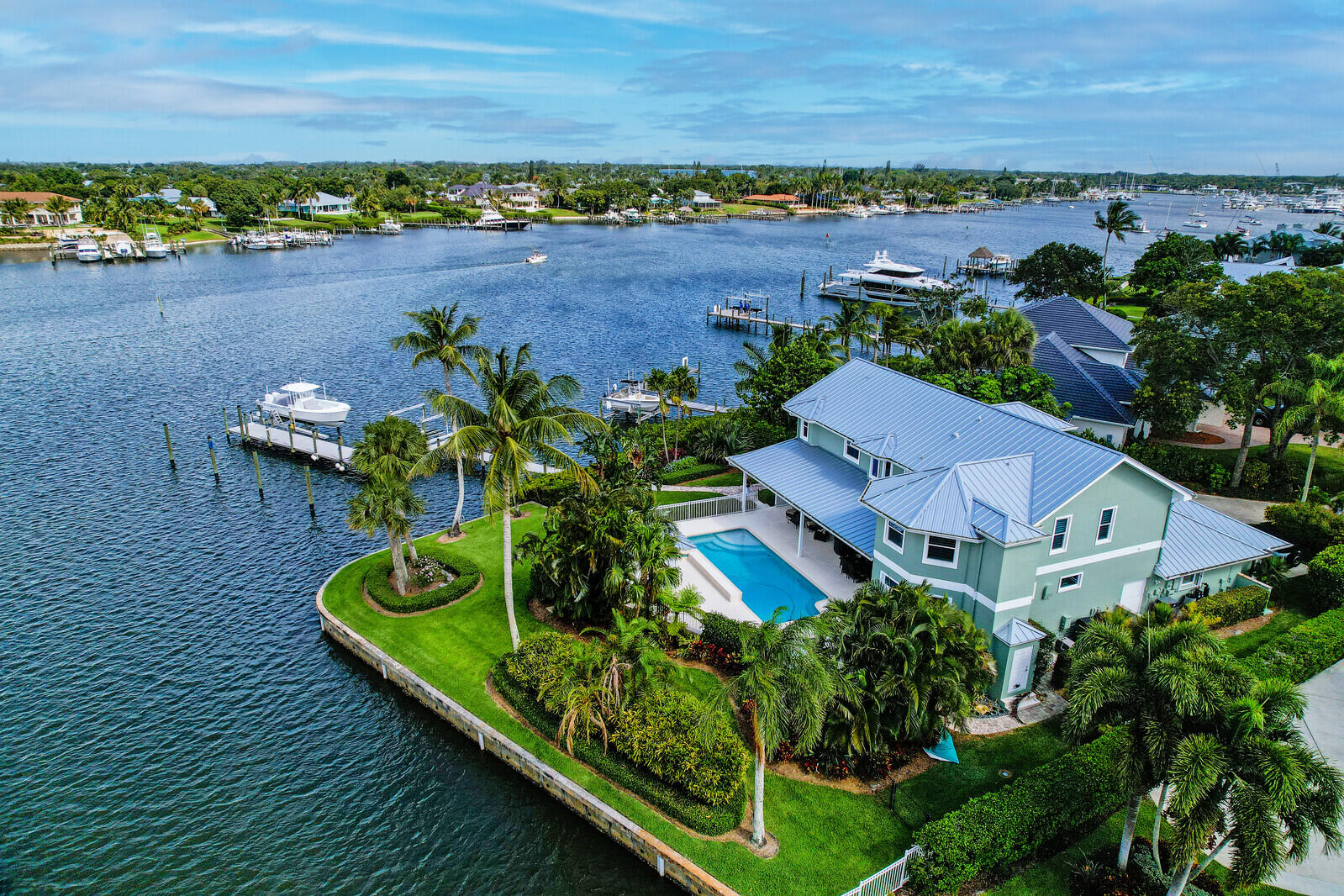 Rare Waterfront  Point Lot in Mariner Cay located on the historic Manatee Pocket.  Sweeping water views from nearly every room offers the finest in waterfront living with no expense spared fixtures & finishes that will please & impress today's particular home buyer.  
Soaring ceilings welcome you w/ custom lighting, crown molding & hardwood flooring.  Chef grade kitchen features a Wolf gas cook-top, double wall oven w/ warming drawer, Sub-Zero refrigeration, granite counters & entertaining buffet. Access the second level living from the beautiful feature staircase or the home's private elevator opening to the fourth bedroom or home office. Comfortable master suite with French doors opening to your private balcony. Master bath w/ free standing soaking vessel bathtub, separate shower, vanity & dual sinks. Large master wardrobe & closet  with accessory island, custom wood closet storage & shelving. 
Mariner Cay is a secured gated waterfront community where boaters enjoy easy access to the Intracoastal waterways & the crystal blue waters of the Atlantic Ocean.   
Additional notable features include; New impact windows (all but 6 windows), accordion shutters, hard wired generator, 1000 gallon propane tank, two tankless water heaters, 24,000 boat lift, new dock, 2018 new metal roof, Plantation shutters, custom built-ins for the den & dining rooms. Arthur Rutenberg built.