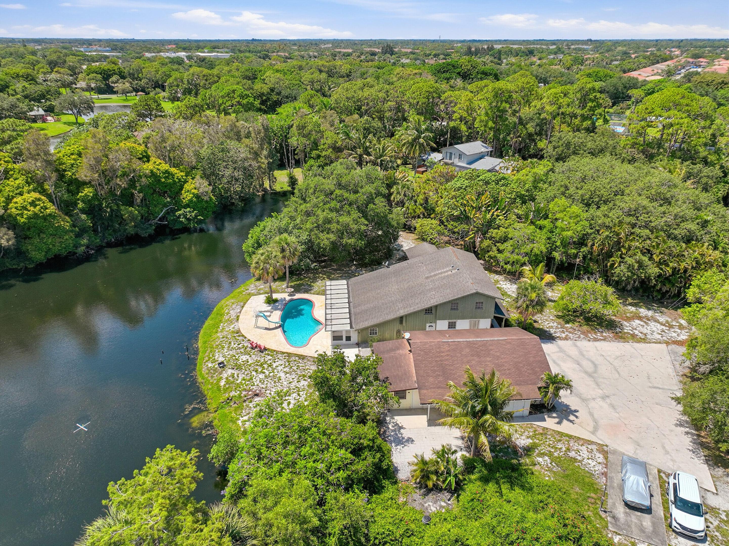 Come see this hidden Boynton Beach Gem, situated on 1.93 agricultural-zoned acres in a private, off-the-beaten-path setting with only a handful of surrounding homes. Full of charm, space, and possibility, this rare property features a 3-bedroom wood-frame residence, pool, detached 2-car garage with efficiency apartment, and travel trailer hookup. The setting is truly special  private, peaceful, and filled with potential for the buyer who wants room to create their own vision. Refresh, renovate, or reimagine the property into your own private estate-style retreat. Property is being sold as-is. A rare opportunity to own nearly 2 acres of privacy, space, and possibility in Boynton Beach.