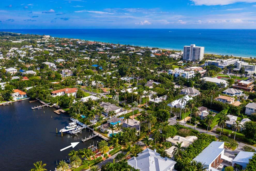 Located just two blocks from the Atlantic Ocean and Atlantic Ave, this direct Intracoastal residence offers the best in beach area living. Set back on the yacht basin, the property boasts stunning water views and dockage with nearby ocean access. The Nantucket style home enjoys a charming curb appeal with white picket fence and Chicago brick driveway. The expansive corner parcel enjoys 106 feet of frontage on Seabreeze Ave and over 150 feet of depth on Basin Dr. The four bedroom home features amazing views of the Intracoastal; hardwood floors; first floor master bedroom; and access to the pool, patio and waterfrontage with private dock and easy access to the ocean via nearby inlet. Enjoy waterfront living with shops and restaurants of Atlantic Ave and beautiful beach just blocks away.