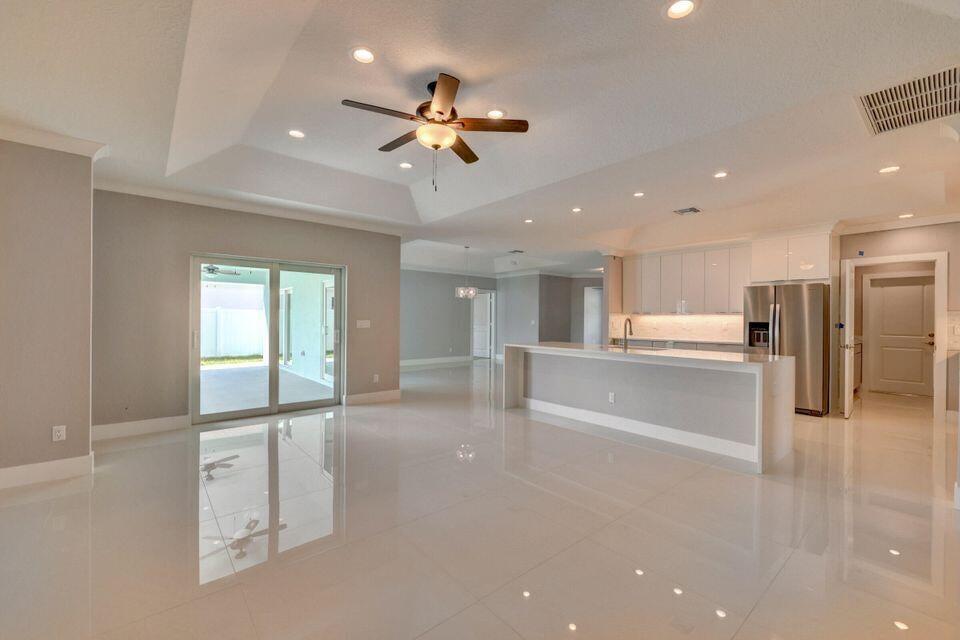 Brand-New 2026 Construction! No HOA. Enjoy breathtaking Florida sunsets and birdwatching from this beautiful 5-bedroom, 3-bath home overlooking O.L. Peacock Sr. Park & Lake. Conveniently located just minutes from Tradition, I-95, the Turnpike, shopping, dining, and hospitals. Features include a private office, den/family room, impact windows and doors, metal roof, fully fenced yard, 42-inch cabinets, granite countertops, stainless steel appliances, crown molding, and 32" x 32" porcelain tile throughout the main living areas. The spacious primary suite offers dual walk-in closets, a designer shower, and a freestanding tub. Move-in ready! Photos are of a previously sold model and may not reflect actual finishes. Associate is related to Seller.
