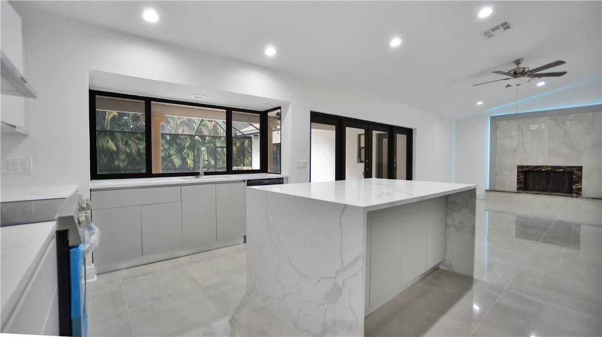 This beautifully remodeled Coral Springs home is the move-in-ready rental you've been waiting for. Bright, open, and tastefully updated with a modern design, the home features vaulted ceilings, impact windows and doors, and stylish finishes throughout. The flexible fourth room can be used as a bedroom, home office, den, or guest space.  The kitchen and main living areas flow seamlessly to the screened-in pool, creating an ideal setup for indoor-outdoor living. Enjoy relaxing or entertaining poolside with the added convenience of a summer kitchen. Rarely available and thoughtfully upgraded, this home offers comfort, style, and functionality in a desirable Coral Springs location. Lease terms longer than one year may be available.