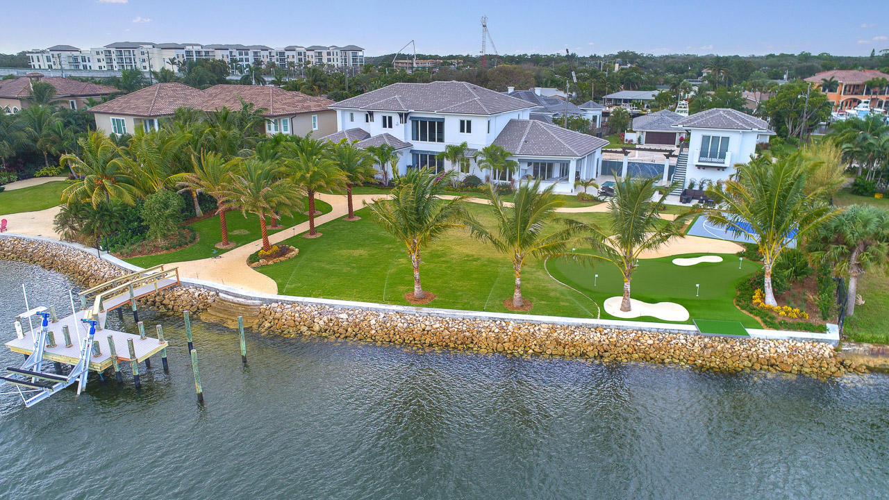 Fantastic new Intracoastal estate with an expansive backyard and 160’ of frontage overlooking the Juno Beach Preserve. Within walking distance to the Beach and East exposure, this custom residence has 5 bedrooms in the main house and a completely separate guest house with one bedroom, a kitchenette, laundry and a one car garage. The main residence boasts a Chef’s kitchen with top of the line Thermador appliances, leathered marble tops and back splashes, two dishwashers, gas oven/cooktop and a butler’s pantry. The large master bedroom has his and her walk-in closets, and expansive bathroom with separate water closets and an adjacent laundry room. The covered loggia has electric screens and a complete summer kitchen with a Lynx gas BBQ, ice maker and two refrigerators. The custom heated  pool has fountains and waterfalls and overlooks the Sport Court and putting green in the backyard. The dock has electric and water and a 14,000lb boat lift.
