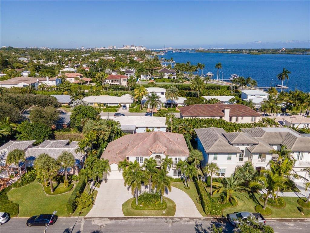 Custom built home on the lake block in the highly desirable SoSo neighborhood.  Beautiful area adjacent to the exceedingly popular walking path of Flagler Drive.  Views of the intracoastal from the balconies of two of the three bedrooms on the second floor.  All five bedrooms have their own private ensuite.  The master is located on the first floor with its grand double door entry, hardwood floors, built-ins, tray ceiling and entrance to veranda and pool.  The master ensuite offers double vanities, Roman tub and separate shower embellished with travertine tile.  This 5 bedroom plus den, 6.5 bath home is bright and airy with vaulted ceilings and a winding staircase leading to the second floor.  Kitchen is open concept with island, quartz countertops and Kitchen Aid SS appliances. Slip away to your oversized den and seclude yourself from the rest of the home.  Home is equipped with an elevator, impact windows and whole-house generator.  French doors lead to the serenity of your poolside veranda in your backyard oasis.  Pool offers a swimming resistance feature.  THE TWO CHANDELIERS IN THE DINING/LIVING AREA AND THE CHANDELIER IN THE FOYER ARE EXCLUDED FROM THE SALE. This stunning home is located close to Palm Beach, downtown West Palm and Palm Beach International Airport.