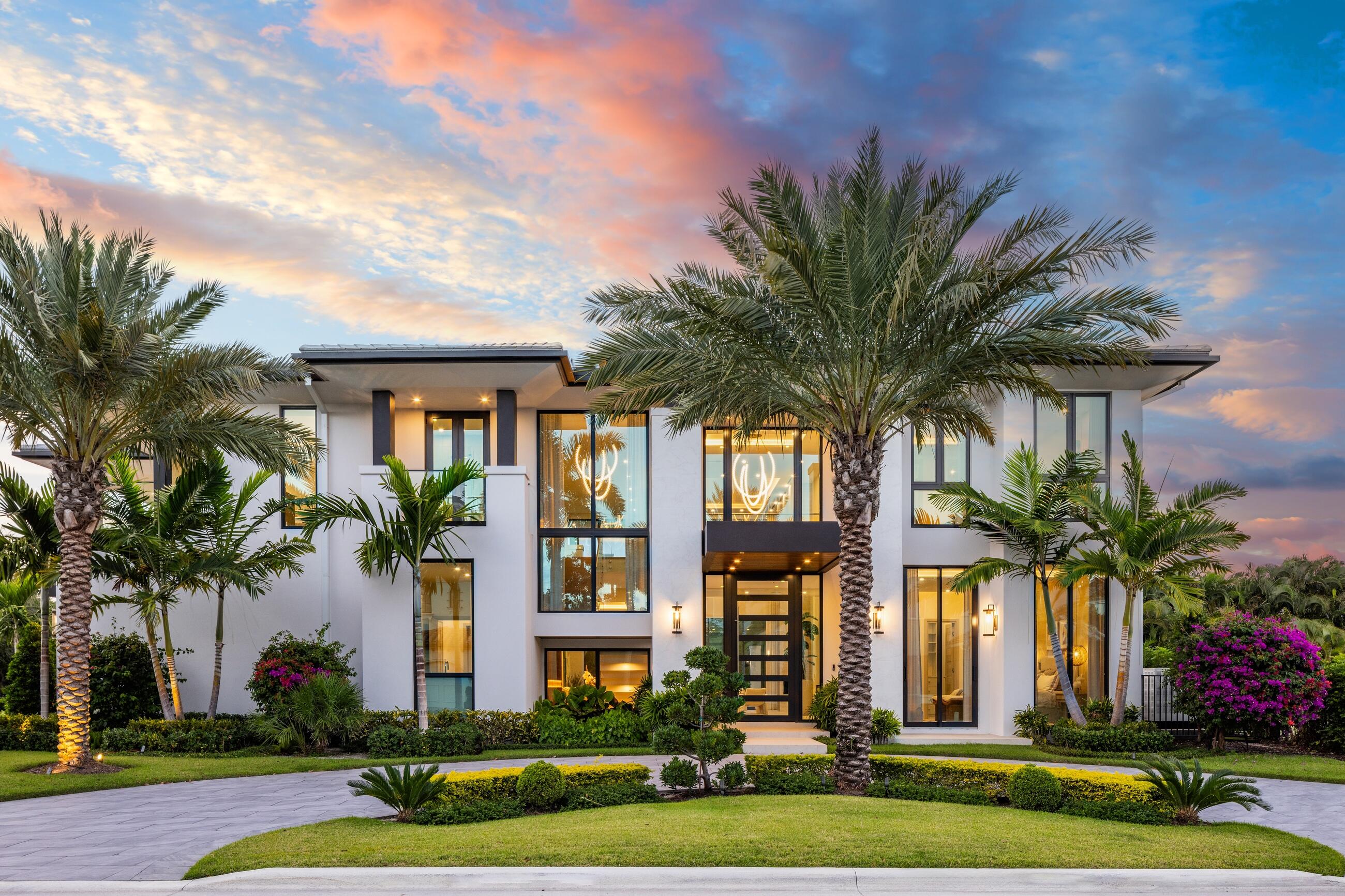 2498 Queen Palm Drive in Boca Raton's Royal Palm Yacht & Country Club stands as a newly completed, fully furnished 6-bedroom, 8.1-bath estate by Albanese & Sons, BE Design, and ZLMN Style Design, offering an elevated expression of contemporary luxury. From the moment you arrive along the decorative circular driveway, the home exudes refinement, warmth, and an invitation to step instantly into an effortless, turnkey lifestyle. Inside, large-plank white oak floors, porcelain tile, custom lighting fixtures, designer wallpaper, and floor-to-ceiling impact glass create an environment that feels both modern and timeless. The formal living area is anchored by a stunning gas fireplace, setting the tone for refined gatherings and relaxed evenings alike. The gourmet kitchen serves as the centerpiece of the home, thoughtfully equipped with Miele appliances and complemented by a fully customized butler's pantry featuring extensive cabinetry and a second full-size refrigerator. An elegant dining room with a luxurious built-in bar and adjoining temperature-controlled wine room sets the stage for intimate dinners or large-scale entertaining. There is a family room on each level, along with a beautifully appointed club room featuring a full wet bar with refrigerator and ice maker, offering a variety of spaces for relaxation and celebration. Throughout the home, new flatscreen televisions provide a modern amenity for living and entertaining.

Upstairs, the primary retreat captures the essence of private luxury living, with dual spa-inspired bathrooms, dual custom walk-in closets, an additional wet bar, motorized drapes, built in cabinetry, and an attached office that enjoys gentle natural light throughout the day. Five additional ensuite bedrooms and a second laundry room provide comfort and privacy for family and guests. Several upper-level balconies, along with an expansive open terrace, offer places to savor the beauty of South Florida's climate from sunrise to sunset.

The outdoor living experience is a true sanctuary. A resort-style pool and spa are framed by lush landscaping and dramatic landscape lighting that transform the property into a serene evening oasis. The loggia, designed for alfresco dining and lounging, features a summer kitchen with BBQ, a cabana bathroom with shower, and a fireplace, creating an ideal setting for gatherings from casual weekend brunches to twilight dinners for ten beneath the gentle coastal breeze.

Technologically sophisticated and move-in ready, the residence includes a Control4 A/V controller, smart lighting, and motorized shades throughout. The four-car air-conditioned garage provides additional comfort and practicality. With furniture, decor, designer wallpaper, window treatments, custom closets, and every detail thoughtfully curated, this estate requires nothing more than your suitcase. Located just minutes from The Boca Raton, pristine beaches, and the city's finest dining and shopping, 2498 Queen Palm Drive represents a rare opportunity to live beautifully in one of Boca Raton's most sought-after communities.