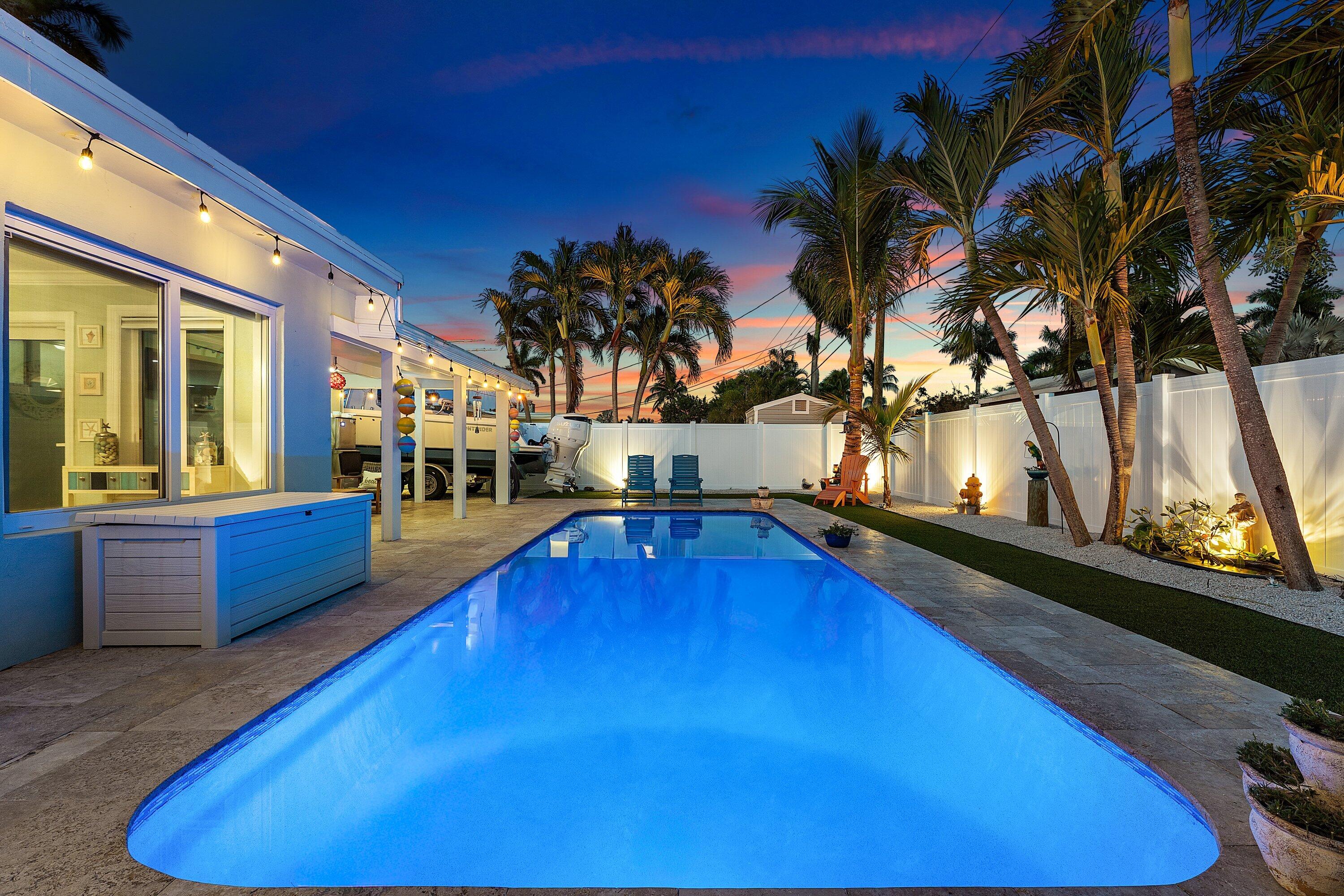 Welcome to your dream coastal lifestyle! Nestled just minutes from pristine beaches and the highly desirable dining, shopping, and entertainment of The Cove, this gorgeous 3-bedroom, 2-bathroom pool home has been masterfully remodeled from top to bottom. The heart of the home features a stunning, spacious kitchen anchored by crisp white shaker cabinetry, premium quartz countertops, and sleek stainless-steel appliances. The kitchen flows seamlessly into a spacious living room centered around a cozy wood-burning fireplace. Throughout the home, you will find beautiful ceramic wood-look tile flooring and custom built-out closets. The primary suite serves as a luxurious retreat, complete with smart built-in storage and a beautifully designed, spacious walk-in shower.   Step outside to your private backyard oasis, designed for effortless Florida living. Lounge by the sparkling pool—beautifully resurfaced with new tile in 2021—surrounded by elegant travertine pavers and maintenance-free synthetic turf. Boaters and outdoor enthusiasts will appreciate the incredible convenience of two driveways for ample parking, plus two dedicated side yards perfect for securing your boat, trailer, or toys. Brand new white PVC fencing. Offering ultimate peace of mind, this home is fully equipped with Impact Windows (2019), a Metal Roof (2019), a Flat Roof (2024), and AC (2020). Pack your bags and bring your boat—this turn-key Coastal Charmer is ready for you to live like you are on vacation every single day!