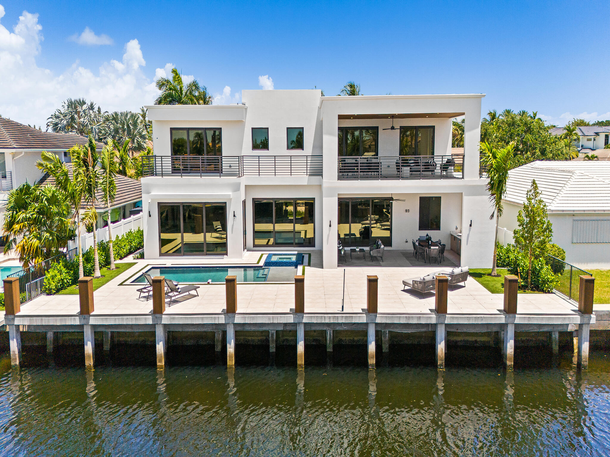 Luxury redefined in this newly constructed waterfront estate, ready for occupancy. Curated with refined finishes & contemporary architecture, showcasing soaring ceilings, walls of glass & an expansive open-concept design. The chef's kitchen features a large center island, premium appliances, gas range, double ovens & a full size wine tower. The private office & intimate waterside club room with wet bar elevate daily living. Upstairs, discover a family room, laundry rm & private balconies overlooking the waterway. The lavish primary suite offers 2 walk-in closets, 2 water closets & a spa-inspired bath. All additional bedrooms are en-suite with custom closets. Outdoor living is unparalleled with a resort-style pool, spa, summer kitchen & private dock ideal for boating. Sq Ft per developer.