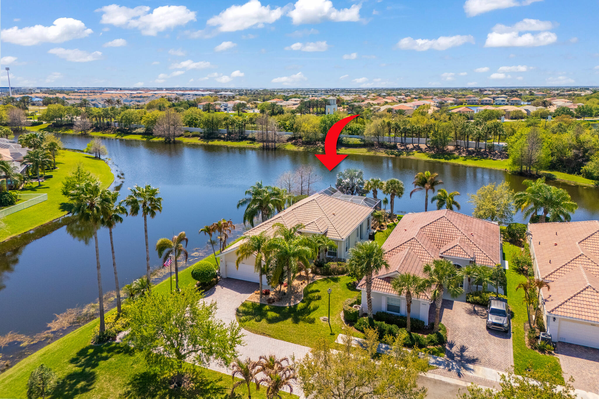 Located in a highly desirable Tradition community, this original owner home sits on a premium corner lot surrounded by water on two sides. A standout feature is the expansive L-shaped driveway, providing ample parking for all your guests. Step inside through the screened entryway and you'll immediately notice the upgraded tile flooring in the living room, kitchen, and den. The glass sliders leading to the pool feature original etched glass artwork that add a unique touch, and the den/study features custom plantation shutters. The kitchen has been updated with stone counters and convenient drawers. The spacious living areas flow seamlessly to the outdoor oasis, where you'll find a heated, screened-in pool and a freshly painted pool deck, perfect for relaxing while enjoying the stunning  water views in all directions!  The owner's suite offers a true retreat with fully remodeled his-and-hers bathrooms, featuring new cabinetry, tile, and etched shower glass. There is ample closet space for all your stuff!  Major system updates include a brand-new 2026 air conditioning system and this home's exterior has been freshly painted in February 2026. The garage has been upgraded with a custom floor and an EV charging station. The enhanced landscaping makes this home stand out in this gated neighborhood within walking distance to shopping and dining in Tradition square! HOA amenities include cable, internet, alarm, lawn care, exterior painting, 24 hour manned gate, clubhouse with social activities, gym, pickleball, tennis, 2 heated pools.