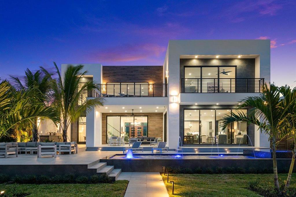 This spectacularly designed direct intracoastal estate is located along a prime No-Wake zone, just a short walk to the Beach and Deerfield's shops and restaurants. Every detail of this stunning home has been meticulously planned, perfect for entertaining or as a private retreat. An expansive kitchen with high-end appliances, sixteen-foot island, a butler's pantry, and endless views. Vast open spaces with volume ceilings, and water views at every turn.  Outside, you'll find a full summer kitchen and a sparkling saltwater pool, complete with deck-jets, bubblers, and sun shelf to round out your private resort. A T-dock with lift is perfect for housing all of your water toys just a short ride to Lake Boca and The Boca Inlet. Take the elevator or stairs to the second floor media loft, and four upstairs bedrooms, each ensuite. The grand master suite features dual balconies accessible through floor-to-ceiling glass doors, custom built closets, a morning bar, and oversize bathroom with shower and free-standing tub.