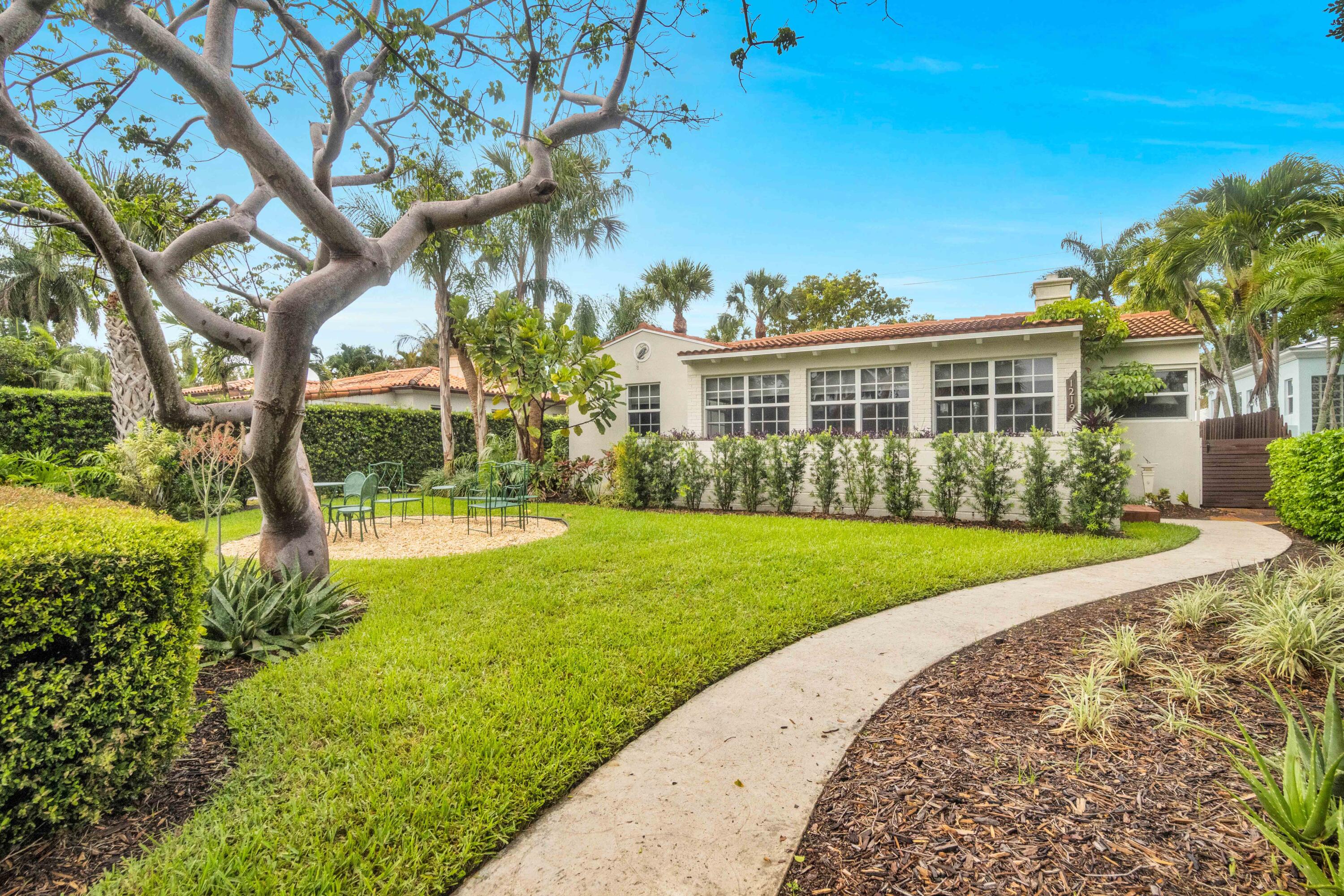 Charming historic CBS home in sought-after Parrot Cove, designed by noted architect Edgar S. Wortman, with golf course and Intracoastal views from the front yard. Set on a picturesque tree-lined street, this beautifully maintained residence blends timeless character with thoughtful details throughout. Features include a 2021 30-year roof, impact windows and doors, updated electric service, whole-house 20KW natural gas generator, gas on-demand water heater, and a classic kitchen with granite countertops, new gas range, and office nook. Original Miami-Dade hardwood floors add warmth and charm, while the primary bath offers a Japanese soaking tub and the living room features a working fireplace.  The detached garage with electric and full bath offers endless flexibility as a guest suite, art studio, office, or workshop.  Situated on an oversized lot overlooking the Lake Worth Beach Golf Club, this exceptional home is just moments from the beach, Intracoastal, vibrant downtown Lake Worth Beach, restaurants, shops, and more. Enjoy the best of South Florida living with no HOA—walk to golf, lunch, downtown events, or the ocean from one of the area's most beloved historic neighborhoods.