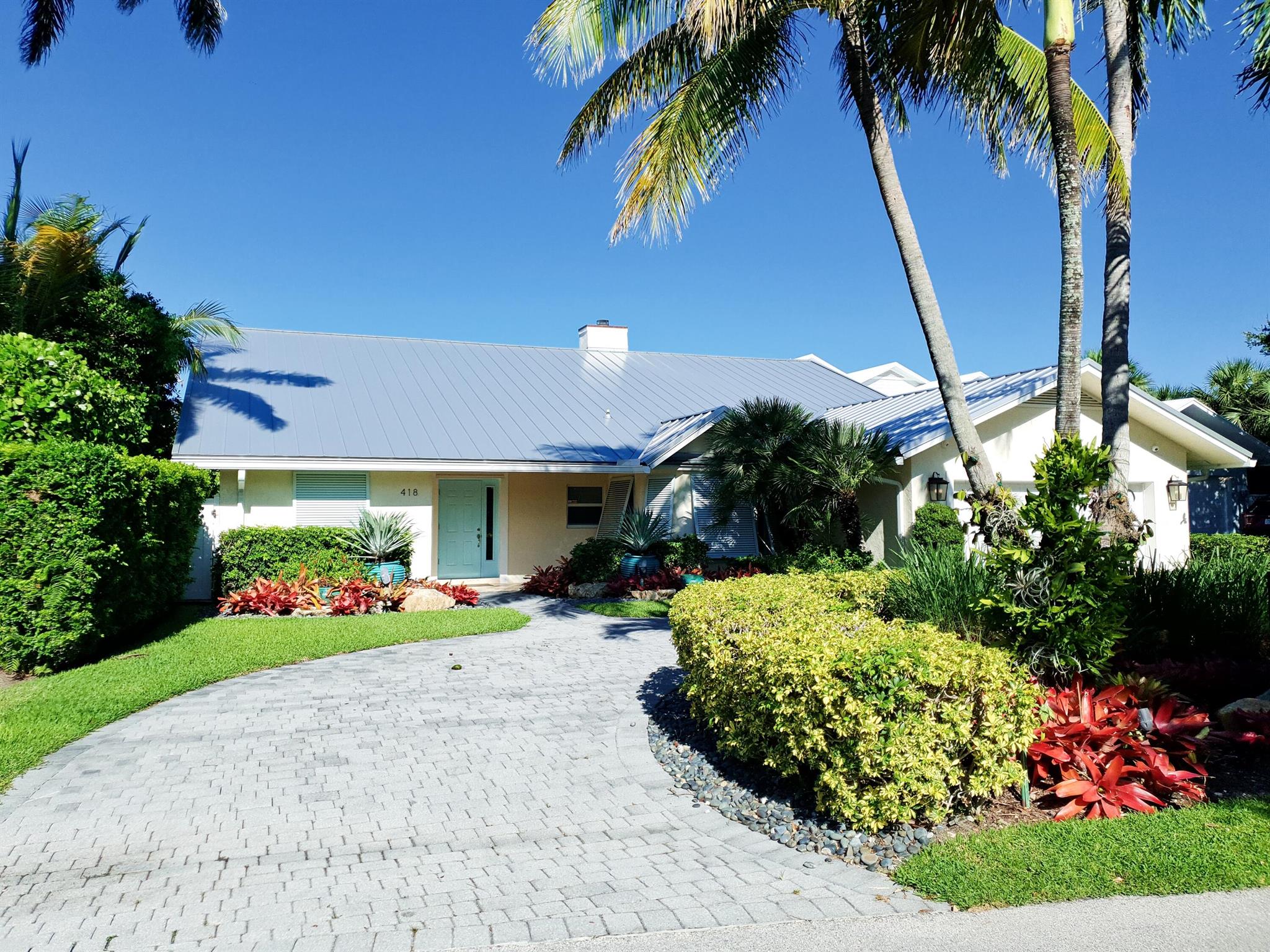 MORE PHOTOS COMING. Tropical water-front paradise located on the coveted north end of Hypoluxo Island. Don't be fooled by the low key entrance to this terrific home with 4,373 sq. ft. under air.  4 BR all with walk-in closets including a 2nd floor private guest suite, 4.5 baths. Walk to the beach, grocery, restaurants, and the 5-Star Eau Palm Beach Hotel. 2-car garage, open floor plan, massive grand living room with vaulted ceilings, hurricane impact windows and doors. Huge kitchen with center island, walk-in pantry, and breakfast nook. Spectacular back yard with lush landscaping, covered patio for outdoor entertaining, and separate outdoor kitchen. Plus your own private dock with intra-coastal access all the way to the Atlantic Ocean. Available for immediate occupancy.