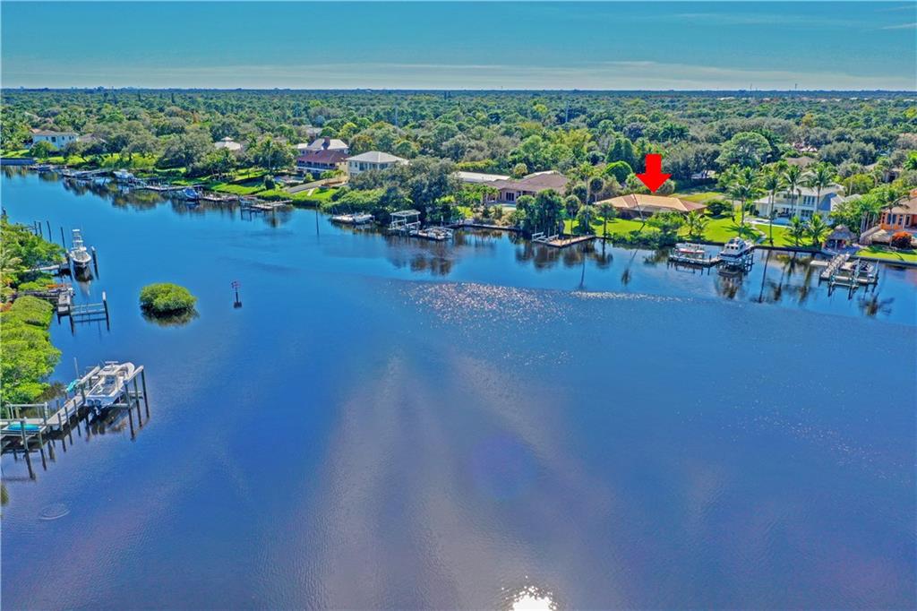Come build your dream estate on this expansive waterfront lot on the Loxahatchee River! Be sure to bring your boat with 100' of waterfront and a scenic 20 minute ride to the ocean. The Loxahatchee River is one of only two federally designated "Wild and Scenic" rivers in Florida. The property boasts nearly an acre with wide water views as far as the eye can see! The home is the last original house in the area, but has been well maintained as a winter retreat from its original owner with a newer metal roof, new AC, sliders that open to a newly refinished and well-maintained, screen-enclosed pool, beautiful landscaping throughout, and a 15,000 lb boat-lift with the current dock.