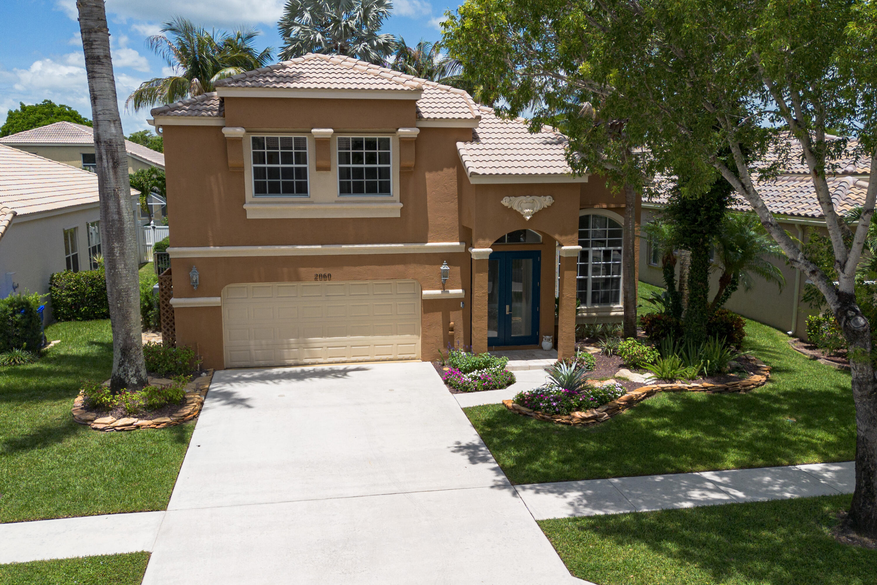 This residence welcomes you with a fresh, elevated blend of modern design, warmth, and style. Glass paneled impact double doors open to a foyer filled with natural light, soaring 16ft smooth ceilings, large-format travertine tile floors, a stacked stone accent wall, and clean structural lines that leave an unforgettable first impression.  The 4/3/2 residence offers the option of four bedrooms or three bedrooms plus a den, along with three full baths &  2 car garage. The 2026 designer-crafted kitchen features custom cabinetry, quartz counters, with a full height quartz backsplash, an oversized quartz topped island with bar seating. Premium stainless-steel appliances and fixtures. A sunlit breakfast nook framed by bold ceiling beams overlooks the pool, creating a serene, retreat like  mood. The sunken family room with a tray ceiling and recessed LED lighting, opens to the back outdoor area that includes a freeform heated pool and spillover spa, all controlled by a Jandy automation system, cool-deck surface. Lush landscaping wraps the fully fenced backyard, creating a private, resort-style escape.  All upstairs bedrooms feature custom built out closets, providing well-designed storage throughout the upper level. The primary suite offers boutique level luxury with boxed panel molding, oversized paned windows, and an elegantly finished ensuite. A full downstairs bedroom/den with an adjacent bath provides ideal versatility for guests, work, or flexible living.  This lovingly maintained home has updated duel A/C systems, updated water heater, & a whole-house RainSoft water-softening & filtration system, providing clean, conditioned water throughout. Located in the sought after gated golf community of Madison Green—where club or golf membership is NOT required. Homeowners enjoy resort style amenities including a pool, spa, fitness facilities, tennis, playgrounds, high speed internet and cable included in the low HOA fees.