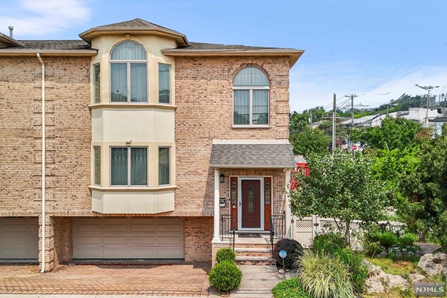 Presenting a meticulously maintained, South-facing all-brick duplex now available for the discerning buyer. The open floor plan features hardwood floors, 9 ft ceilings, large bay windows, custom double rail curtains, and elegant crown molding. The 1st level includes a formal living room, powder room, modern eat-in kitchen, formal dining area, and a spacious living room with a gas fireplace. The 2nd floor hosts the primary suite with 2 walk-in closets and a luxurious en-suite bathroom with a skylight, plus 2 bedrooms and a full bath. The finished lower level has a private entrance, rec room, full bath, direct yard access, and an attached two-car garage. Located 3 miles from the GW Bridge and steps from direct NYC bus service. Newer appliances and smart home features include Ring security, 24/7 cameras, smart lock, Nest thermostats, and MyQ garage. With only two owners since construction, this well-cared-for townhome is a must-see!