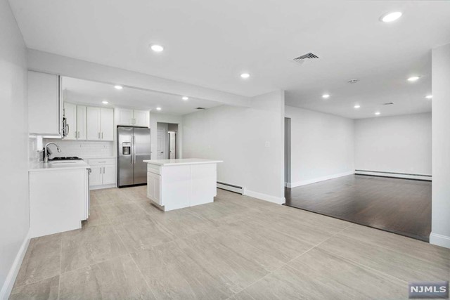 NEW EVERYTHING! Just renovated, very spacious, and move-in ready, modern kitchen w/ NEW stainless steel fridge, dishwasher, range, microwave, cabinets, quartz island and countertops. Very spacious living and dining rooms. Freshly painted bedrooms w/ NEW doors and closets. NEW 2 baths w/ glass shower doors, NEW vanity, toilet, and fixtures. Hardwood floors throughout. Central AC and baseboard heating. Includes 1 garage and 1 driveway parking w/ plenty of street parking avail, plus, use of back yard. Plenty of natural light and great westerly views. Easy access to major highways, shops, groceries, and restaurants. Move in ready. NO PETS PLS. Pictures were taken prior to the current tenants moved in.