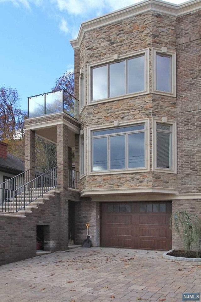 70 FT TOWNHOME OFFERING 3000+ SQ FT OVER THREE LEVELS PLUS ROOFTOP TERRACE. EXTERIOR COMPRISED OF BRICK, STONE, AND EXTENSIVE PRECAST. MAIN LEVEL BOASTS 9FT CEILINGS, OPEN FLOOR PLAN, LIVING ROOM W GAS FIREPLACE, MODERN KITCHEN WITH SUBZERO/WOLF APPLIANCE PACKAGE, TRAVERTINE TILED POWDER ROOM, AND FAMILY ROOM WITH SLIDING GLASS DOOR TO PRIVATE PATIO PERFECT FOR ENTERTAINING. SPACIOUS MASTER SUITE WITH TERRACE OFFERING NYC AND HUDSON RIVER VIEWS, WALK IN CLOSET , EN SUITE MARBLE BATH COMPLETE GLASS ENCLOSED SHOWER, DOUBLE VANITIES, TUB, AND RADIANT HEAT. TWO ADDITIONAL BEDROOMS BOTH OFFER EN SUITE BATHS. 30X16FT ROOFTOP TERRACE WITH UNBELIEVABLE VIEWS OF NYC FROM ALL ANGLES WITH WET BAR AND SUBZERO FRIDGE. GROUND FLOOR COMPLETE WITH TANDEM GARAGE, REC ROOM, AND FULL BATH. ADDITIONAL FEATURES INCLUDE CUSTOM MOLDINGS, KOHLER FIXTURES, VIDEO INTERCOM, TWO ZONE AC, 4 ZONE HEAT. A MUST SEE.