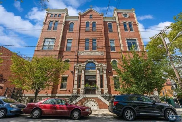 Discover luxury and charm in this 1BR, 1BA + lofted den penthouse in Bergen-Lafayette. Situated in a transformed schoolhouse, it flaunts 14ft living room and 22ft bedroom cathedral ceilings. Immerse yourself in days blessed with ambient mornings, sun-kissed afternoons, and warm golden evenings, courtesy of southern exposure and large windows. Spanning 1066sqft, it promises spacious hosting without the crowded feel. Enjoy penthouse tranquility with minimal shared walls, a modern kitchen with quartz counters, sleek appliances, and a breakfast bar. Benefit from in-unit W/D and a grand walk-in closet. The lofted den is a perfect home office. Elevator, bike storage, and common yard add convenience. Nestled near Liberty State Park, the Light Rail, and new eateries and breweries, it's a dream for those craving downtown proximity with more room and amenities.