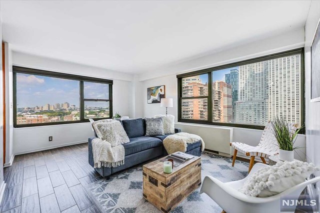 Step into this sun-drenched, recently renovated, sought-after corner unit in one of Downtown JC's most desirable buildings, 135 Montgomery St. This stunning two-bedroom, one-bathroom apartment, situated on a high floor, boasts amazing sunset views and Jersey City vistas. The unit features new tile flooring, a completely gut-renovated bathroom, and new HVAC units for optimal comfort. Each room is equipped with custom closets designed by California Closets and cordless blinds, with the main bedroom offering custom blackout blinds that come with a lifetime warranty. The maintenance fee of $1615 covers TAXES, electric, gas, heat, air conditioning, hot water, water, sewer, and building-related services, making it 40-45% tax deductible.. The convenience continues with the Grove St Path just a 4-minute walk away and the Exchange Place Path about a 10-minute walk. Additional amenities include laundry on the main floor, front desk concierge, and security services. Don't miss out on this ex