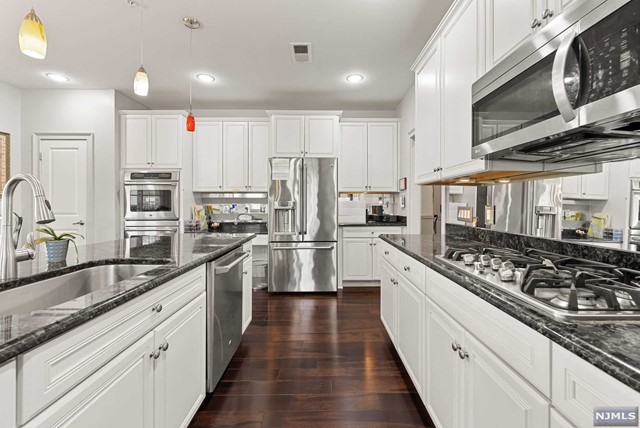 First Floor AND single-floor living at the Four Seasons! This move-in-ready Marigold unit is a spacious 2-bedroom, 2 full bath offering extreme convenience for anyone looking to be on the first floor. Natural light floods the open floorplan complemented with a sizeable foyer, hardwood floors throughout & carpet in the bedrooms. The bedrooms are on opposite sides of the unit, providing privacy and each have their own full bath along with multiple, large Walk-in closets. Complete with In-unit laundry, Central air, Forced hot air, public sewer, public water & Natural Gas. Kitchen features Granite countertops and SS appliances with easy access to family room w/ Gas fireplace as well as outdoor, tiled patio for the perfect setting for a morning coffee! Enjoy the many amenities including 4500 sqft clubhouse, in-ground outdoor pool, tennis courts, fitness center and more! Great location with ease of access to public transportation, major highways, shopping, restaurants, NYC, and more!