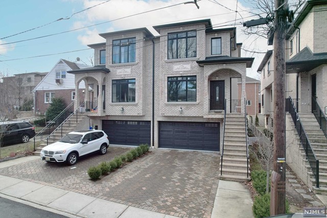 Newly constructed brick townhouse featuring approximately 2800 square feet of living space over three levels, situated in the heart of Fort Lee. The ground level is complete with a 2-car garage, recreation room, office, half bath, and sliding glass door to the patio and yard. The main level boasts 9-foot-high ceilings, an open living room with a fireplace and dining room, a modern kitchen with a waterfall island, top-of-the-line stainless steel appliances, a wine cooler, breakfast area, and sliding glass door to the rear deck. The master bedroom includes an en-suite spa-like bath complete with a tub, glass-enclosed shower, and double vanities. Additionally, there are two additional bedrooms with a full bath in the hallway and a laundry room on the bedroom level. The townhouse also features a multi-zone heating system, central A/C, central vac, oak hardwood floors, and custom moldings throughout.