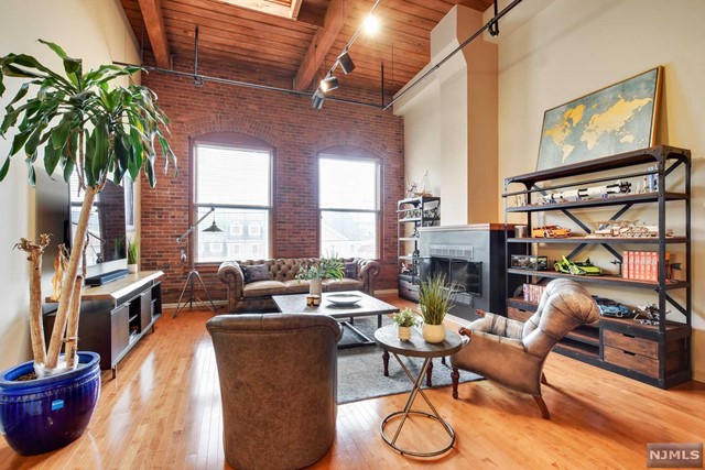 Chic, loft-style 2 bdrm/2bth condo! Exposed brick walls, 18 ft high ceilings, and oversized industrial windows provide the perfect balance of an urban vibe and suburban living! Features of this corner unit include a wood-burning fireplace, beautiful hardwood floors, a skylight, large windows etched into the historic industrial brick walls, a large walk-in closet w/ a custom barn door, an in-unit laundry area, a new furnace and water heater, an updated kitchen with granite counters & s/s appl, and much more!